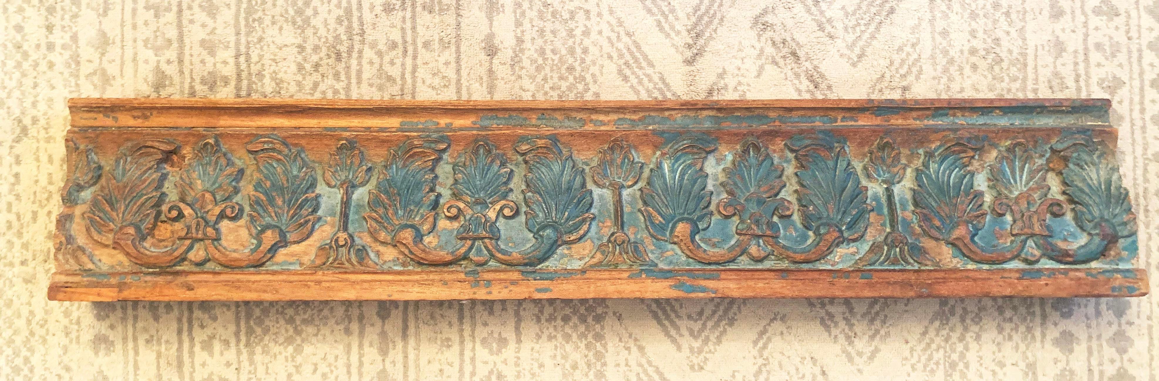 Antique Indian rosewood temple door beam carving with green distressed paint, circa 1900. Made of solid rosewood. Thick green paint has faded and chipped in many areas, revealing the carvings and rich colored rosewood below. Repeated scrolling