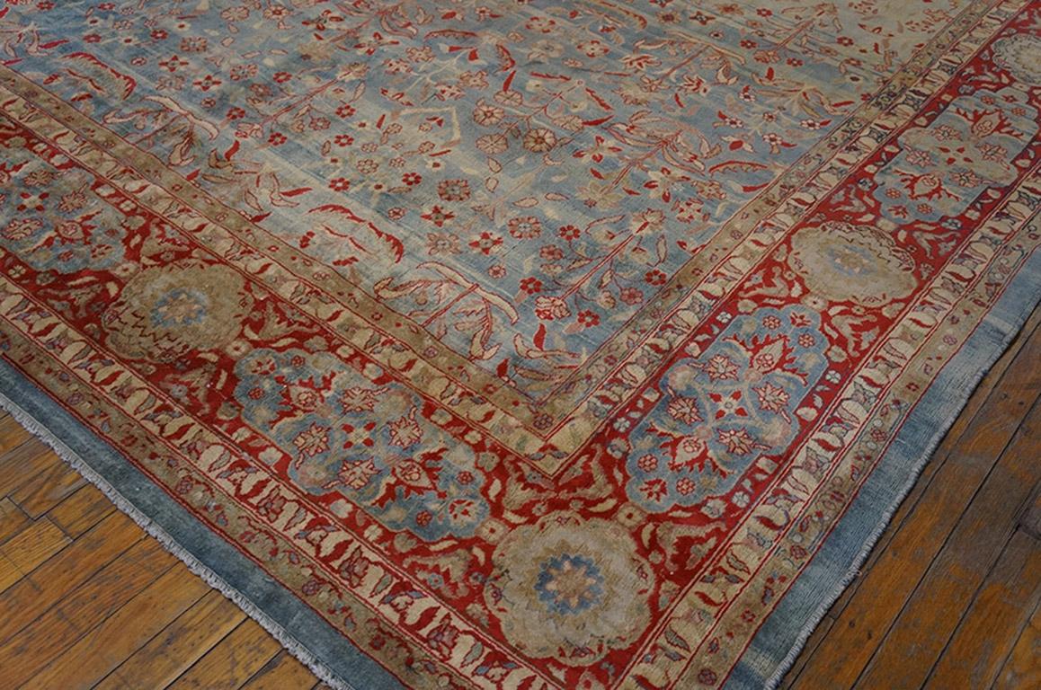 The field gently cloud-abrashes to pale blue from a powder-beige tonality, and it displays a unidirectional close and detached full flower pattern in basically offset rows. Classic cartouche and rosette red main border with abrashed light blue