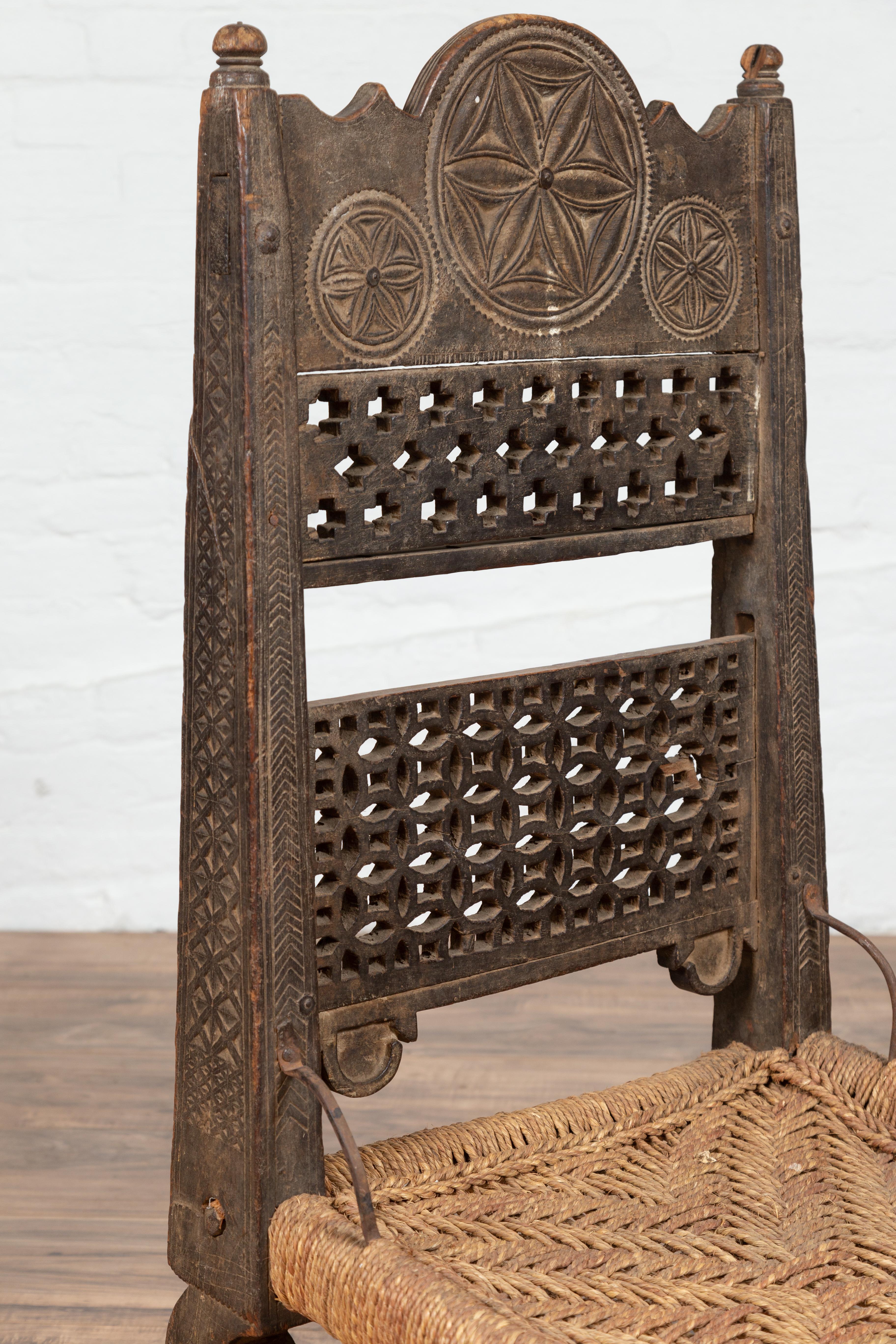 Hand-Carved Antique Indian Rustic Low Seat Wooden Chair with Fretwork Accents and Rosettes For Sale