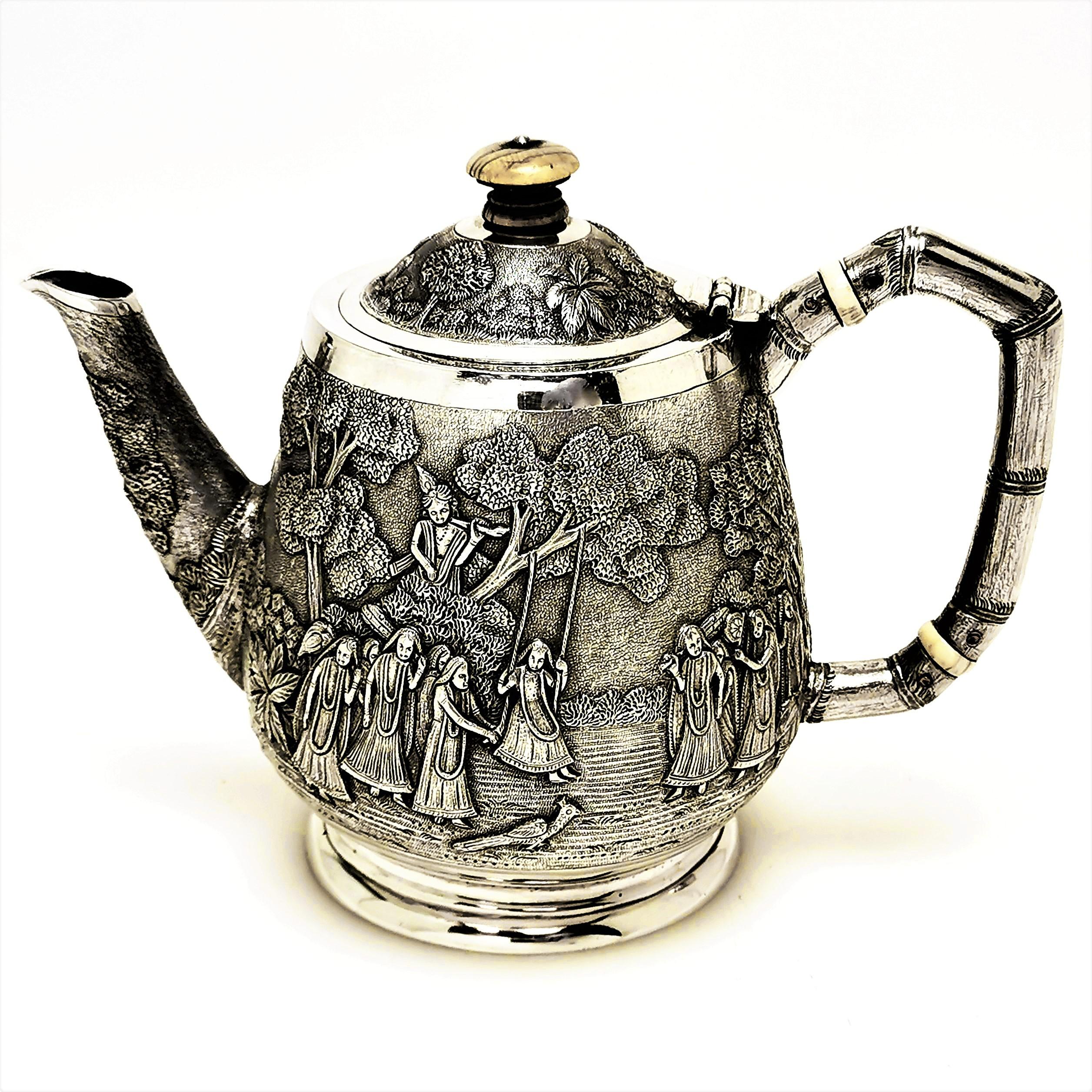 A beautiful Antique Indian Bachelor's Teapot decorated with a gorgeous chased design. The Design shows a group of women dancing on the one side and a pair of men driving cattle on the other. each group is shown surrounded by leafy trees and plants.