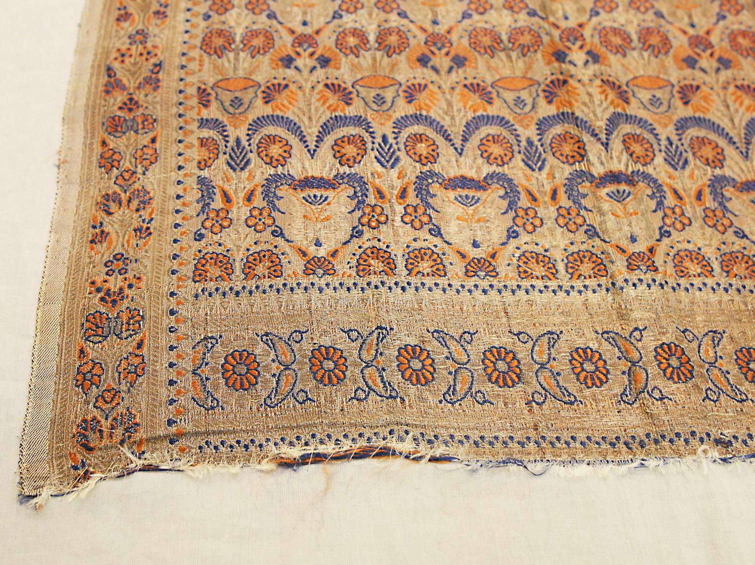 This is a rare antique silk Indian textile woven during the end of the 19th century that measures 164 x 56 CM in size. The design of this rug is based on an early 18th century repeating vase design. In this specific example, there are alternating