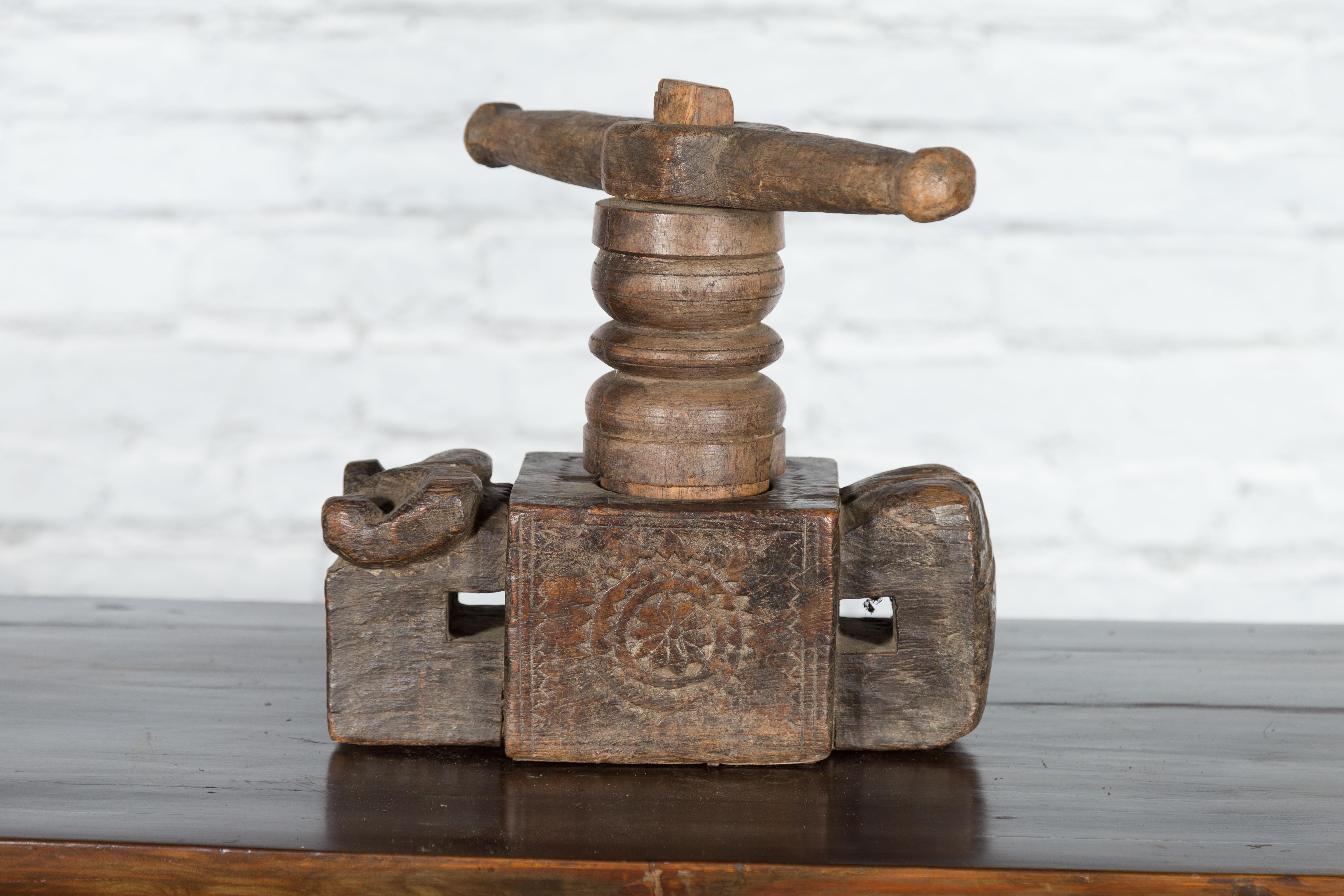 An Indian antique carved wooden hand noodle press from the 19th century, with stylized ram motif. Created in India during the 19th century, this wooden piece was originally used to hand make noodles. Showcasing a vice press, the body is adorned with
