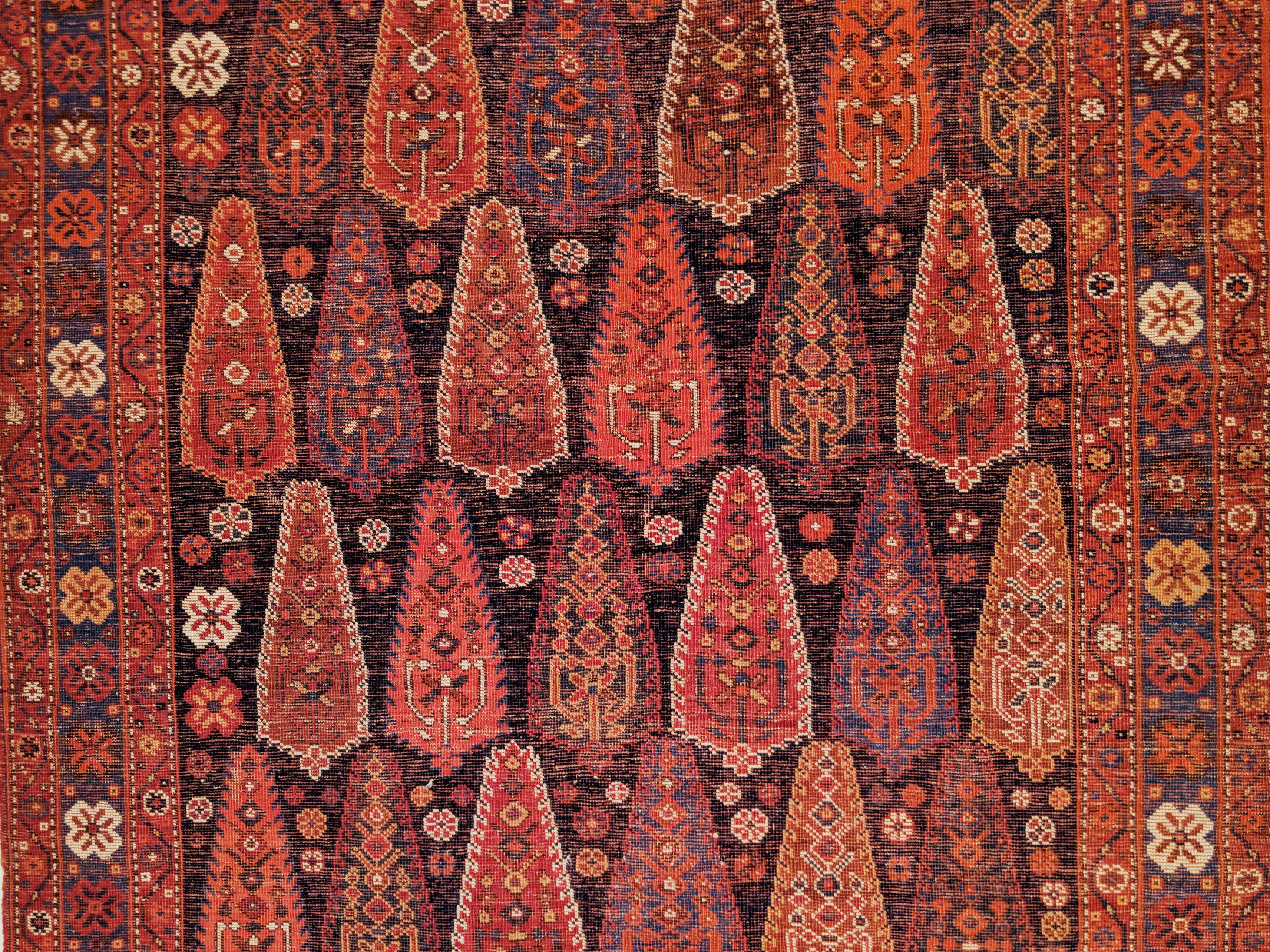 Un très beau tapis tribal Eleg, très ancien, qui se distingue par son élégance.  motif ascendant de cyprès polychromes sur fond bleu indigo. Ce glorieux exemple présente une gamme complète de couleurs remarquablement étincelantes mais patinées,