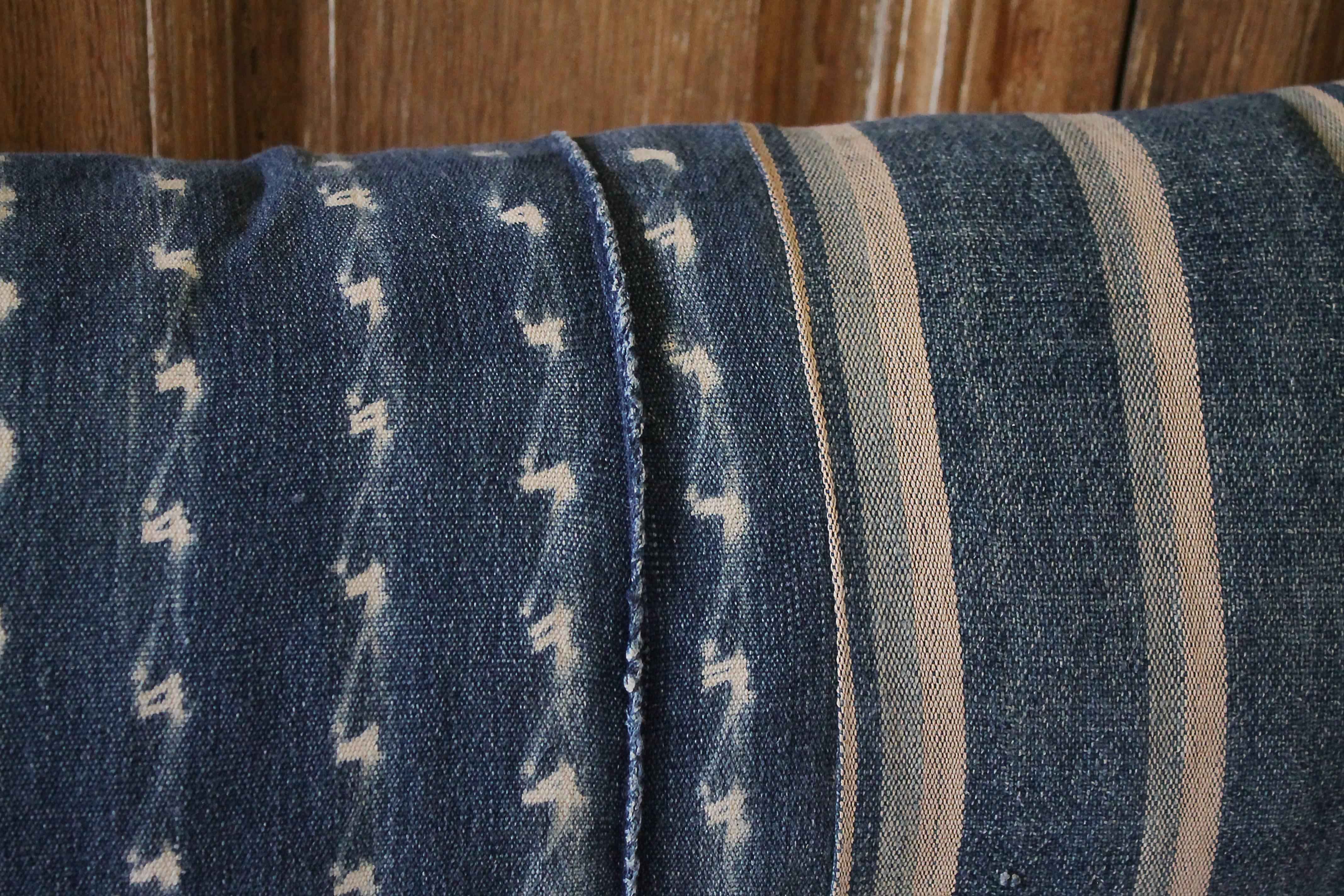 Custom pillow made from antique textiles by Full Bloom Cottage. Antique indigo blue batik lumbar pillow with down insert and hidden zipper closure. Back side of the pillow is finished in an antique French linen in natural. Measures 13 x 30.