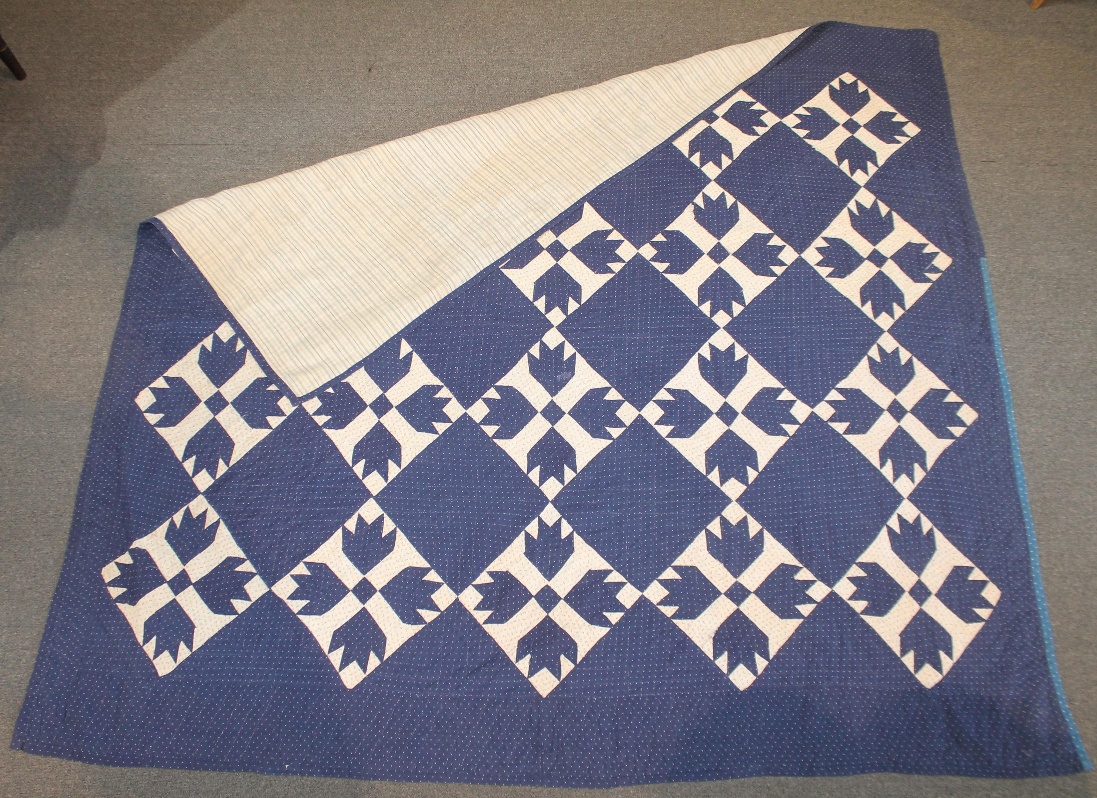 Cet édredon du XIXe siècle en tissu calicot bleu indigo et blanc à motif de pattes d'ours est en bon état. Il a été trouvé dans le Midwest et a un support en tissu doux de flanelle grise. C'est donc une couette agréable et durable à utiliser. Super