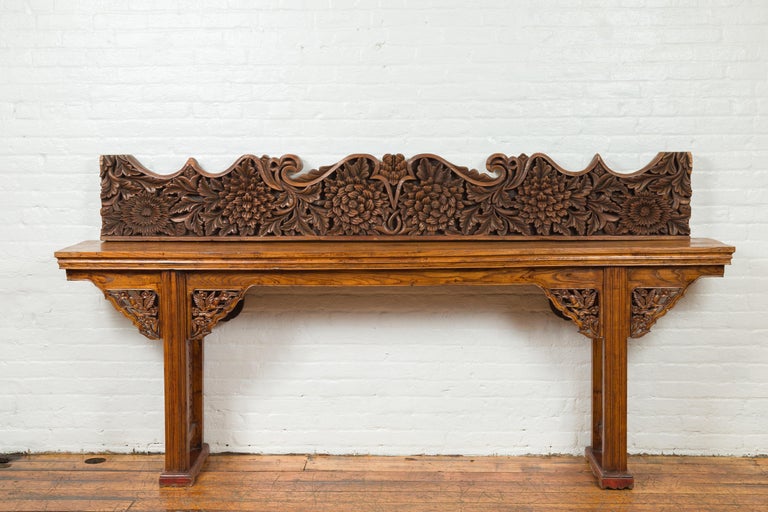 An antique Indonesian carved teak architectural panel from the 19th century, with floral and foliage décor. Found in an entryway, this teak architectural panel can be displayed horizontally or vertically, depending on your needs. Its scrolling