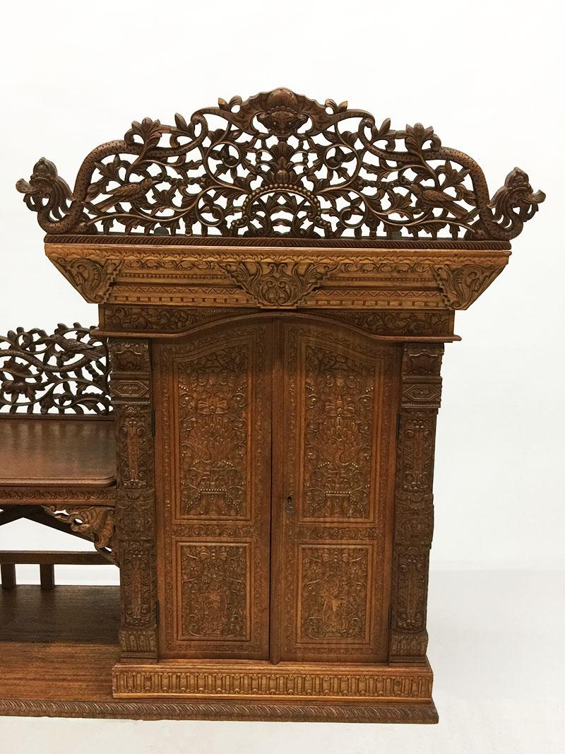 Antique Indonesian hand carved wall unit, cabinet

A beautiful hand carved teak wooden wall unit or cabinet with a closet with a door and 2 open compartments

The cabinet is richly hand carved wood with scenes of wayang figures, dragons, birds,