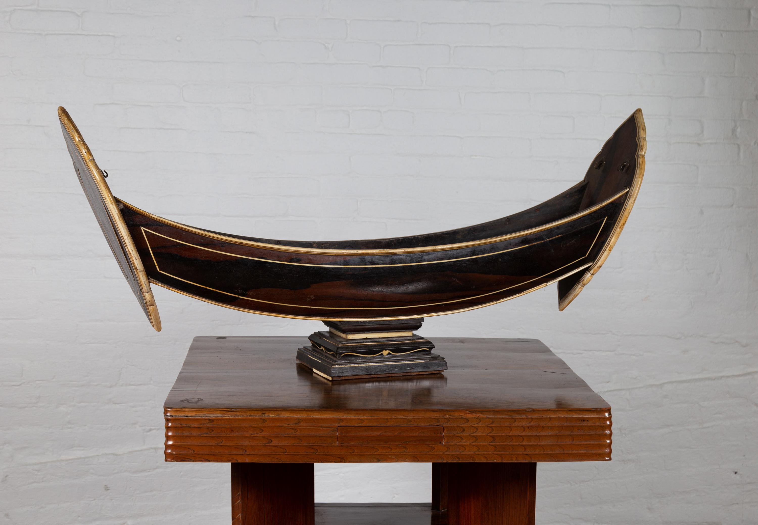 20ième siècle Modèle de bateau indonésien ancien fabriqué à la main sur piédestal avec incrustation d'os sur bois en vente