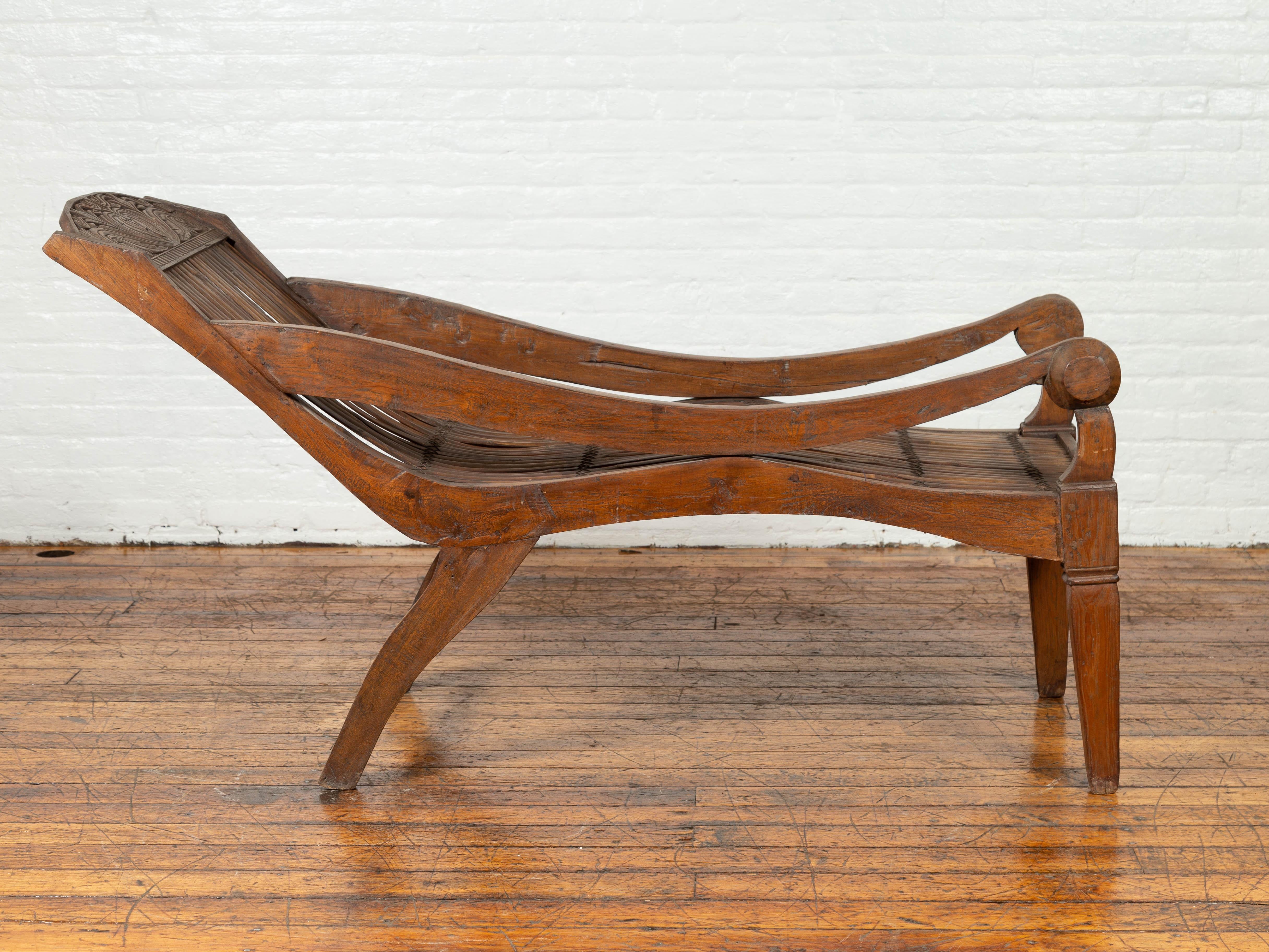 20th Century Antique Indonesian Reclining Plantation Chair with Bamboo Slats and Carved Décor For Sale