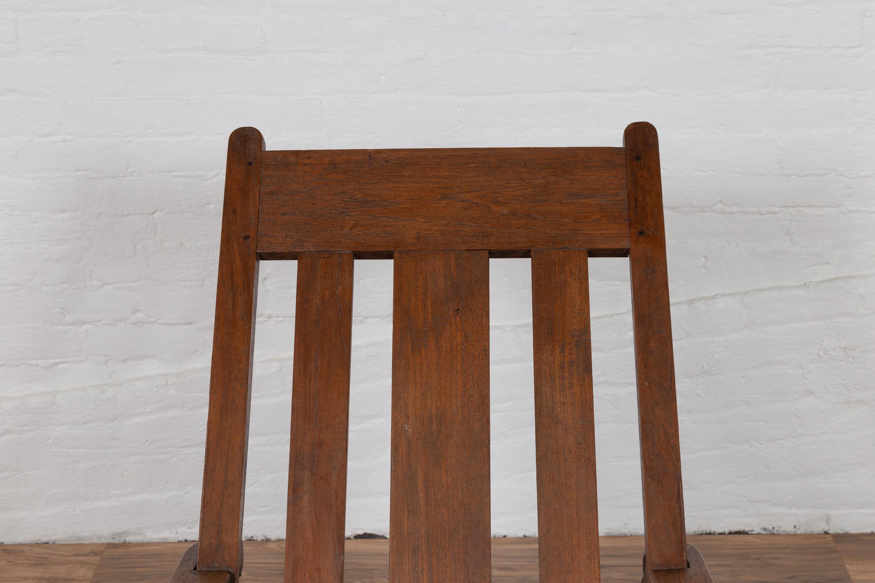Ancienne chaise longue de plantation Coloni du début du 20e siècle, originaire de Madura, en Indonésie, avec dossier incliné et longs accoudoirs. Née à Madura, au large de la côte nord-est de Java, cette chaise longue de style colonial hollandais