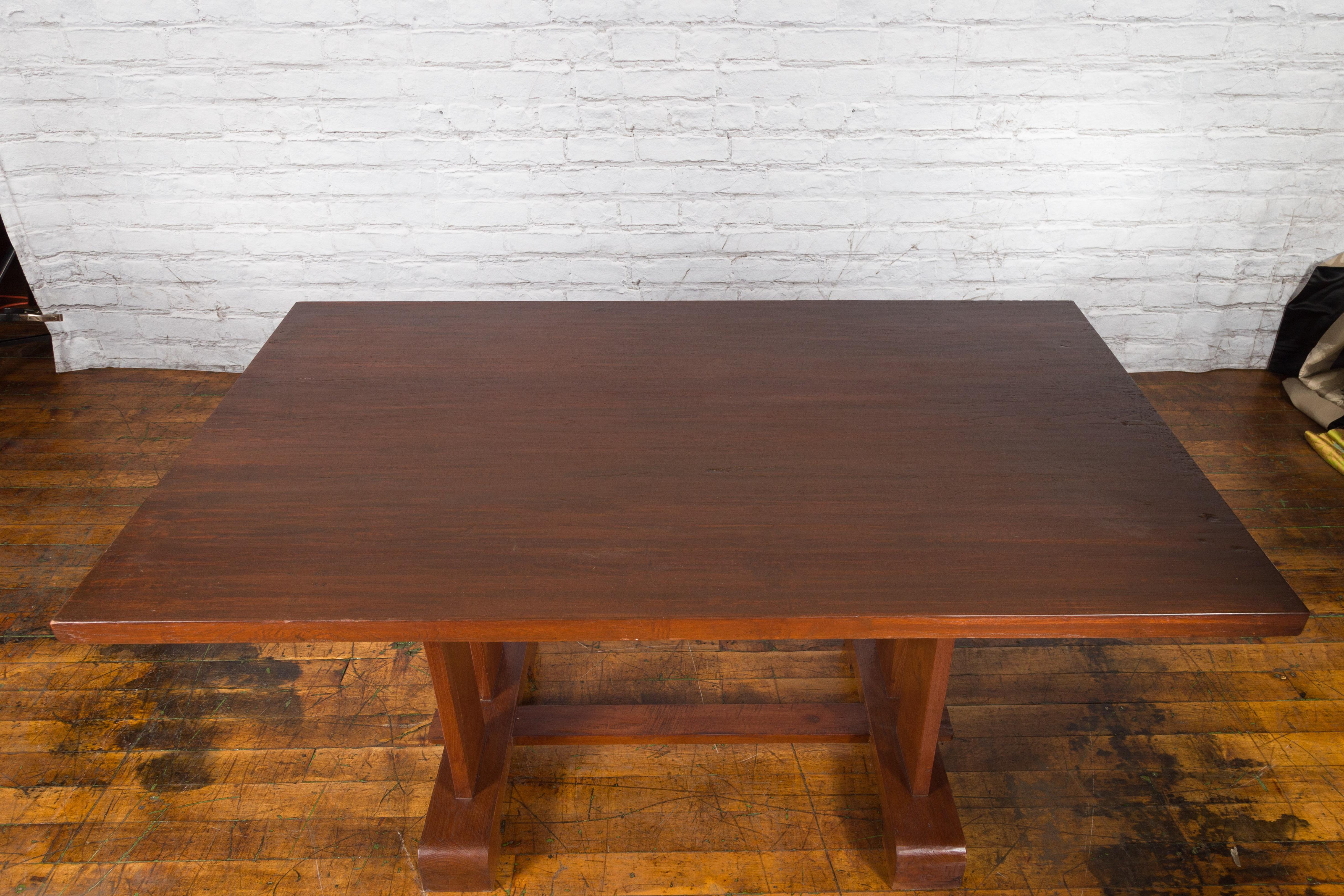 20th Century Antique Indonesian Teakwood Dining Table with Trestle Base and Brown Patina For Sale