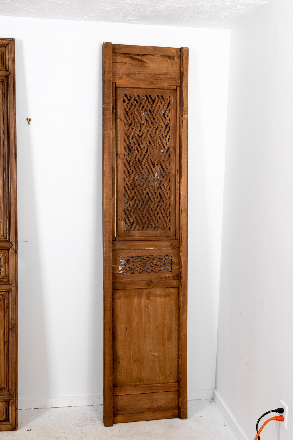 Ensemble de trois paravents anciens en bois sculpté indonésien, datant du début du XXe siècle, avec panneaux de tracés décoratifs. Chaque panneau présente divers motifs sculptés tels que des fleurs de lotus, des animaux, des oiseaux et des outils de