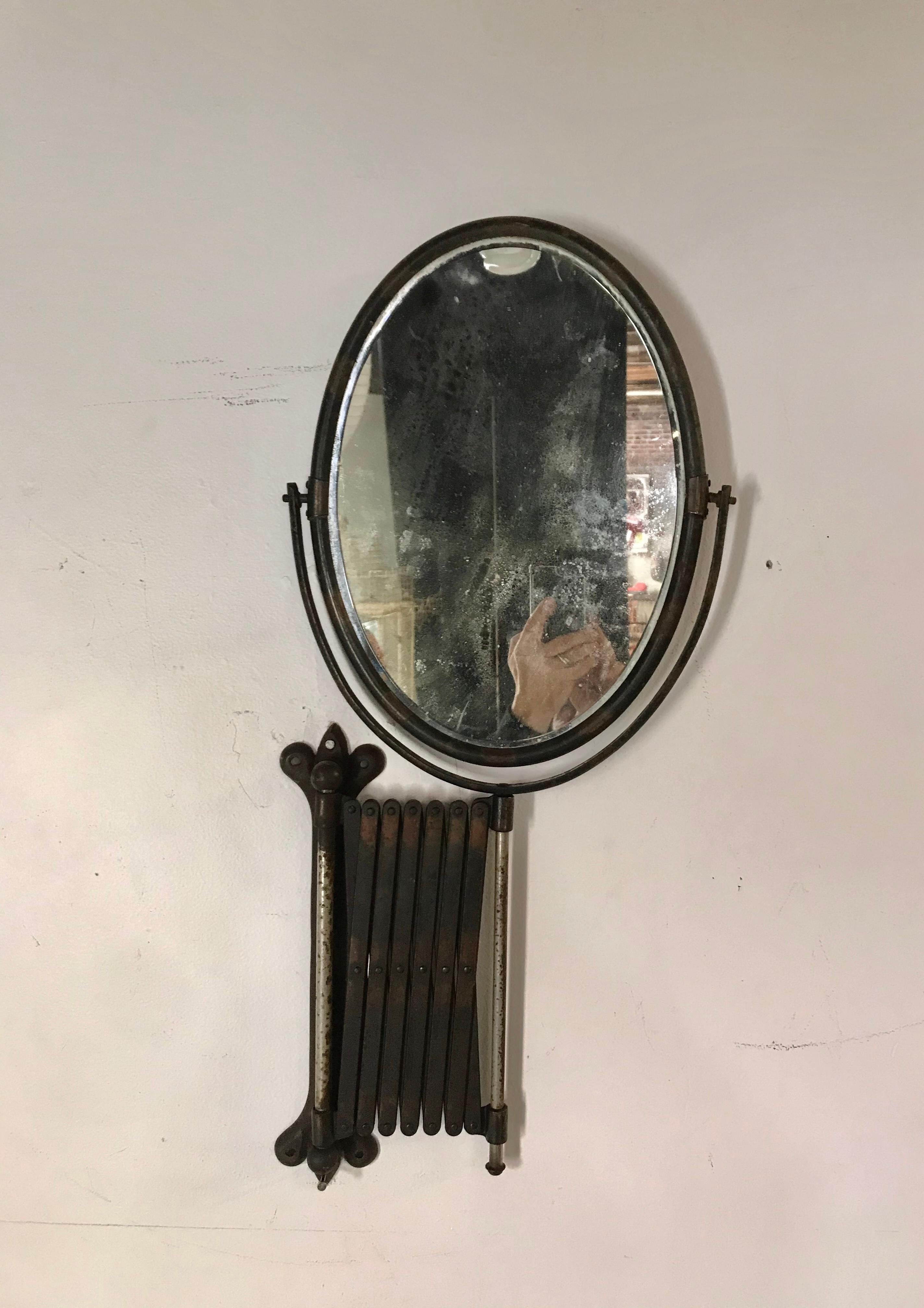 Large oval high Victorian era accordion bronze wall mirror. Very good vintage condition, showing wear and oxidation. Fully functional, patina to all surfaces.

Measures: Width 12½ - 41½ x height 26½ inches. (Mirror Width 10¼ x Height 14½ inches).
