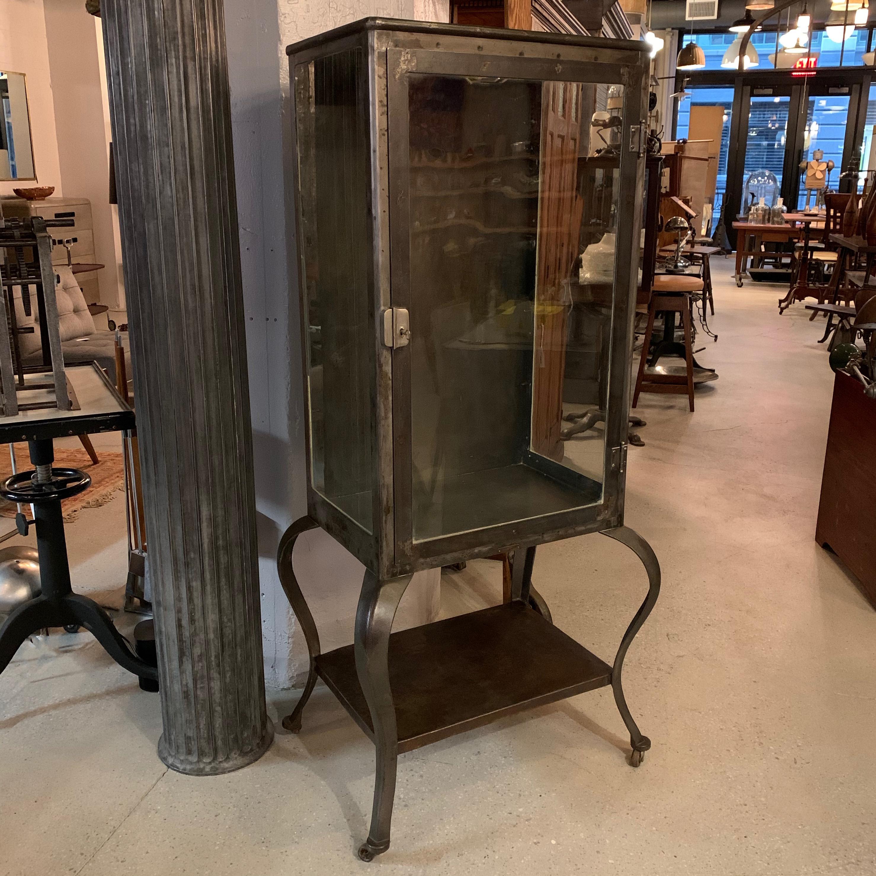 Antique, lockable, apothecary, display cabinet circa 1890s features a brushed steel frame with cabriole legs, glass on 3 sides with open display storage on the bottom. The cabinet comes with 2 glass shelves and it's key. Cabinet dimensions are 24