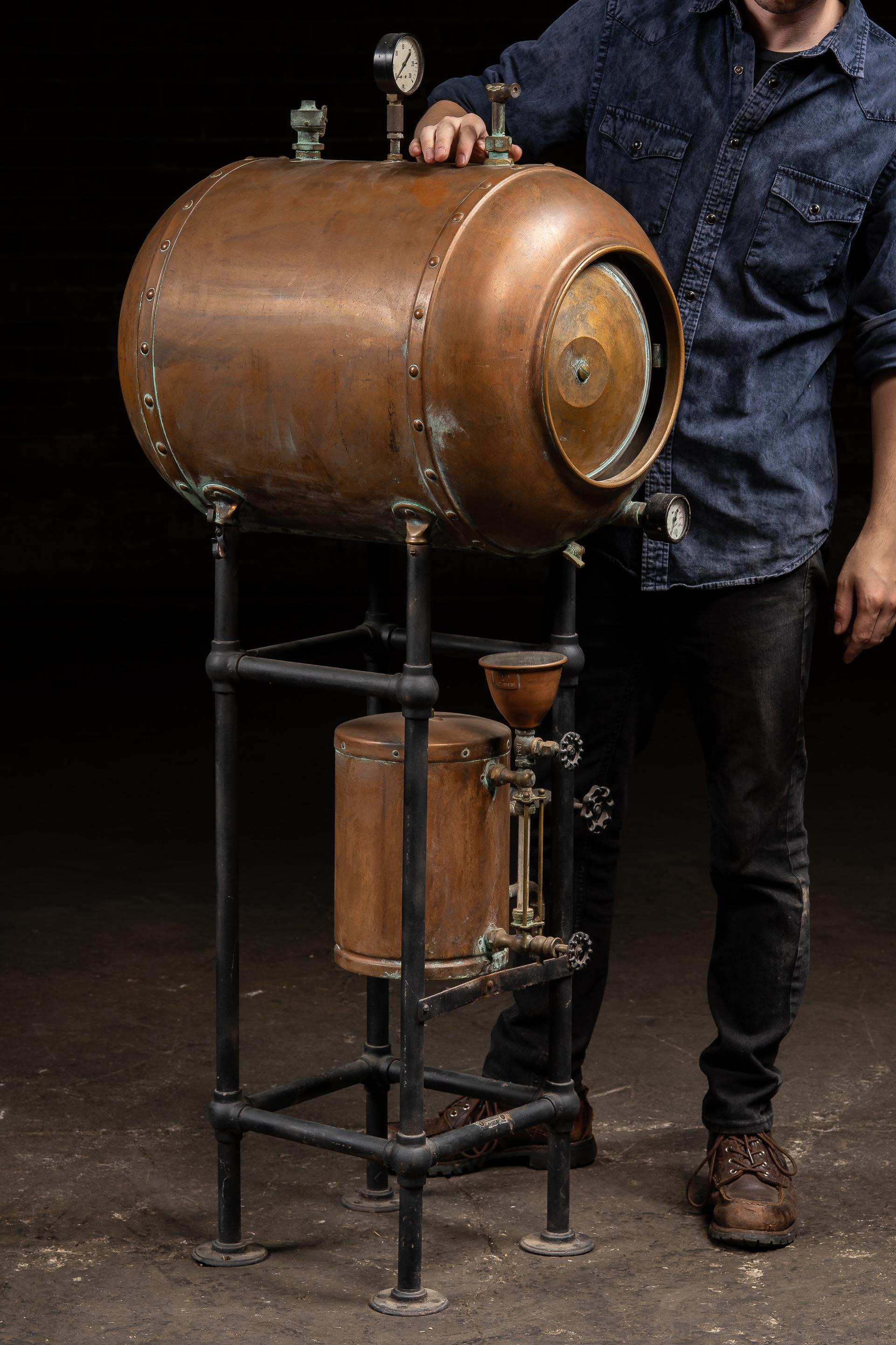 c. années 1920-1930 ; (probablement) L. Schuler & Co. - Chicago, IL

Très bel appareil à pression industriel en cuivre monté sur un cadre en fer noir. Le réservoir cylindrique présente des coutures rivetées, deux manomètres et de multiples soupapes