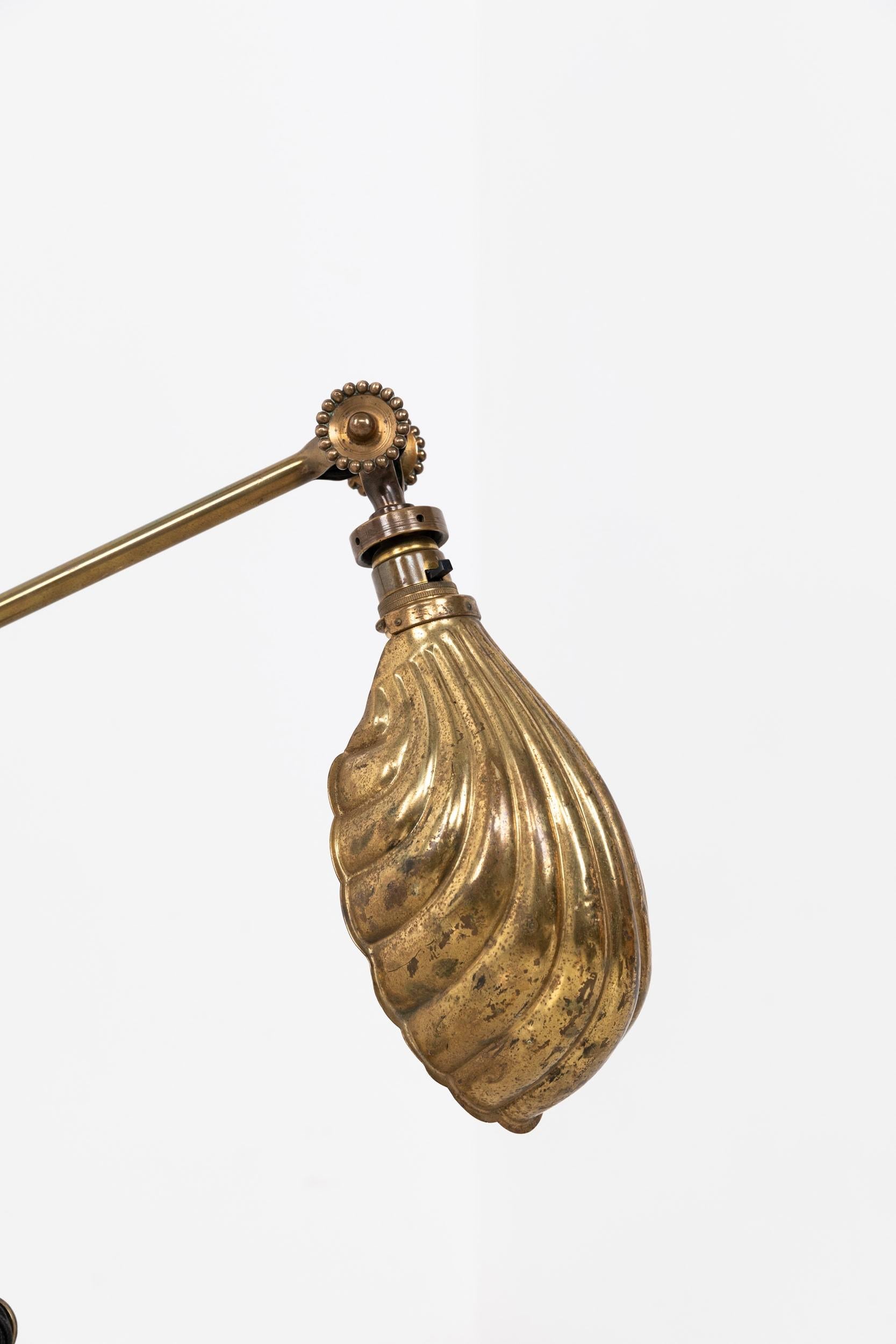 

A beautiful example of an early Dugdills desk lamp. c.1915

Surviving in wonderful original condition. All brass construction, featuring decorative and weighted base with acanthus leaf design, 'rosettes' for hand tightening the joints and shell