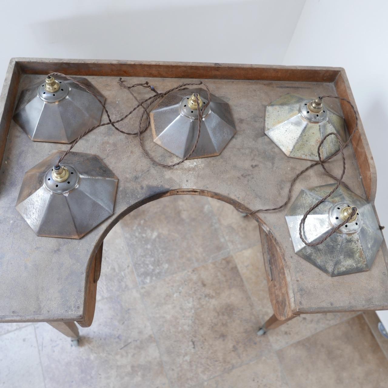 A run of up to five mirrored pendant lights. 

England, c1920s. 

Amazing wear and natural patina to the metal outsides and the glass reflector plates. 

Three have matching patina, two were likely kept in a different room and have a different