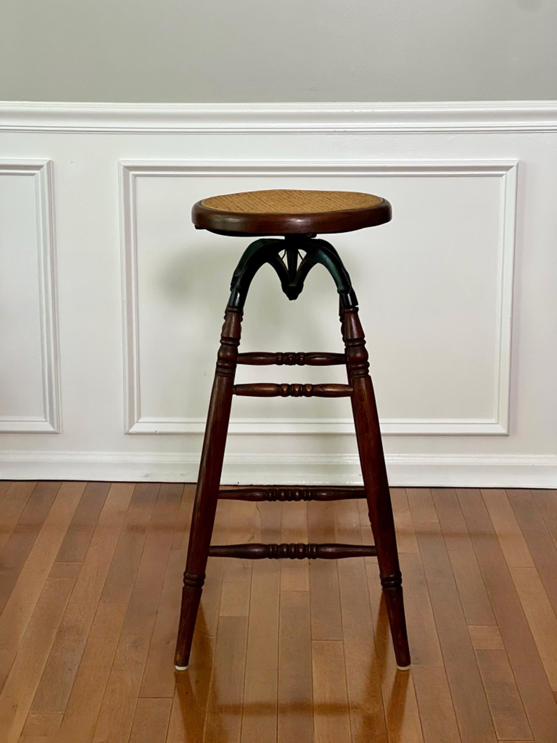 Ancienne époque victorienne américaine chêne et fer pivotant rédaction, tabouret d'architecte avec siège de canne, circa 1900.  L'assise en rotin à hauteur fixe peut pivoter à 360 degrés, soutenue par des supports en fer noir incurvés sur des pieds