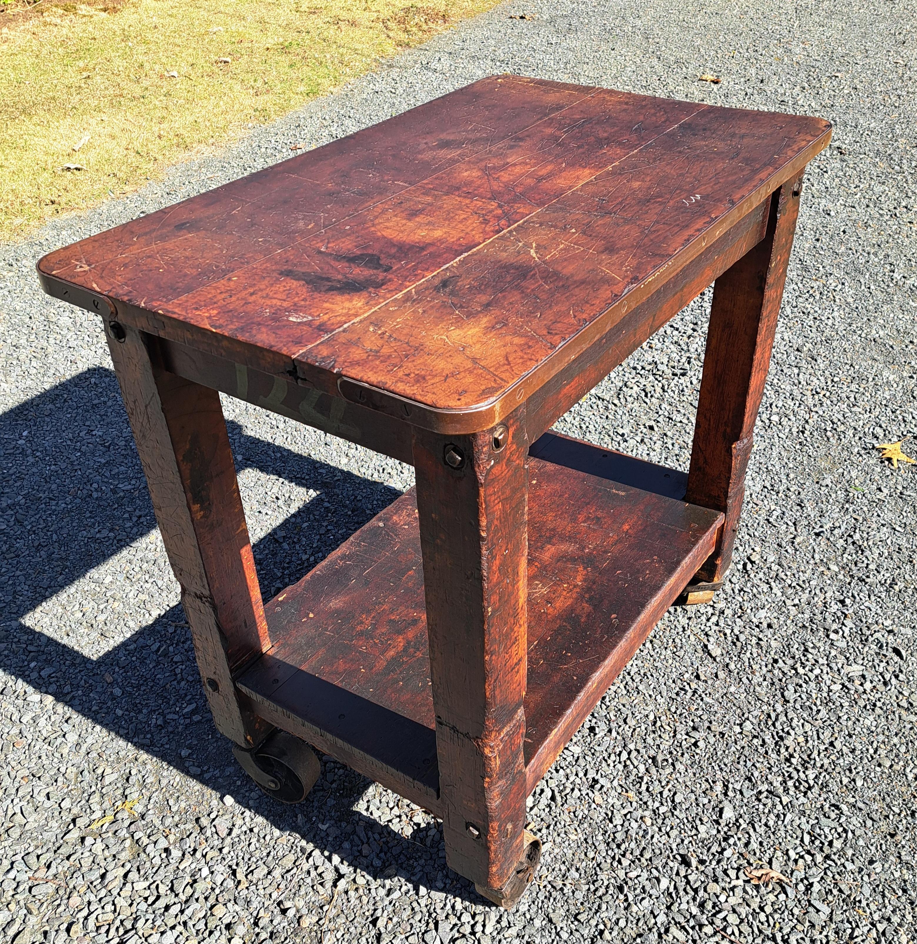 Mesa/isla rodante industrial antigua con ruedas giratorias de hierro fundido.  Mide 38,25