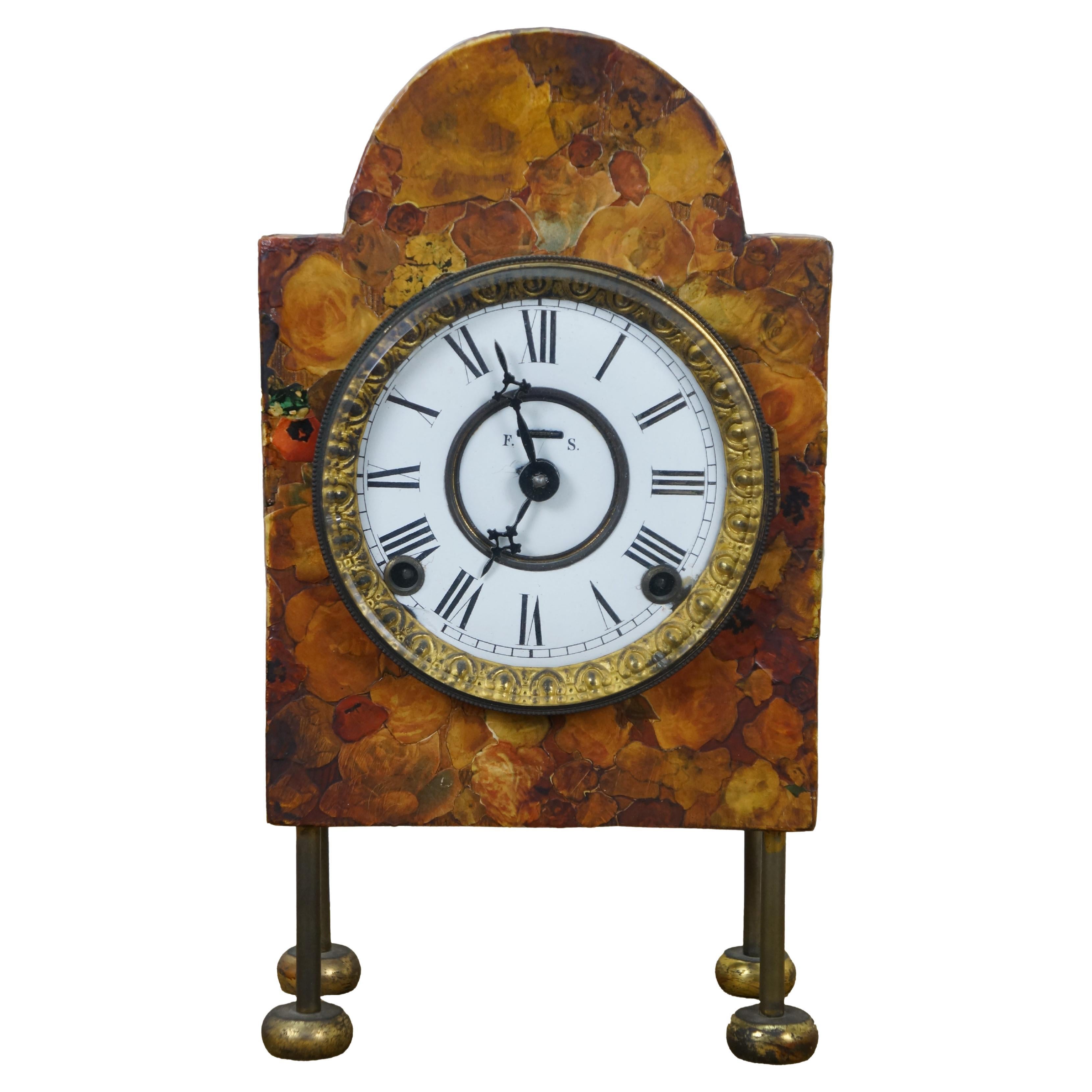 Antique Art Deco style floral marbelite decoupage, key wound, chiming mantel clock. Rectangular wood case with arch top, decoupaged with red and brown roses and flowers, standing on four brass legs with tablet shaped feet. White enamel face with