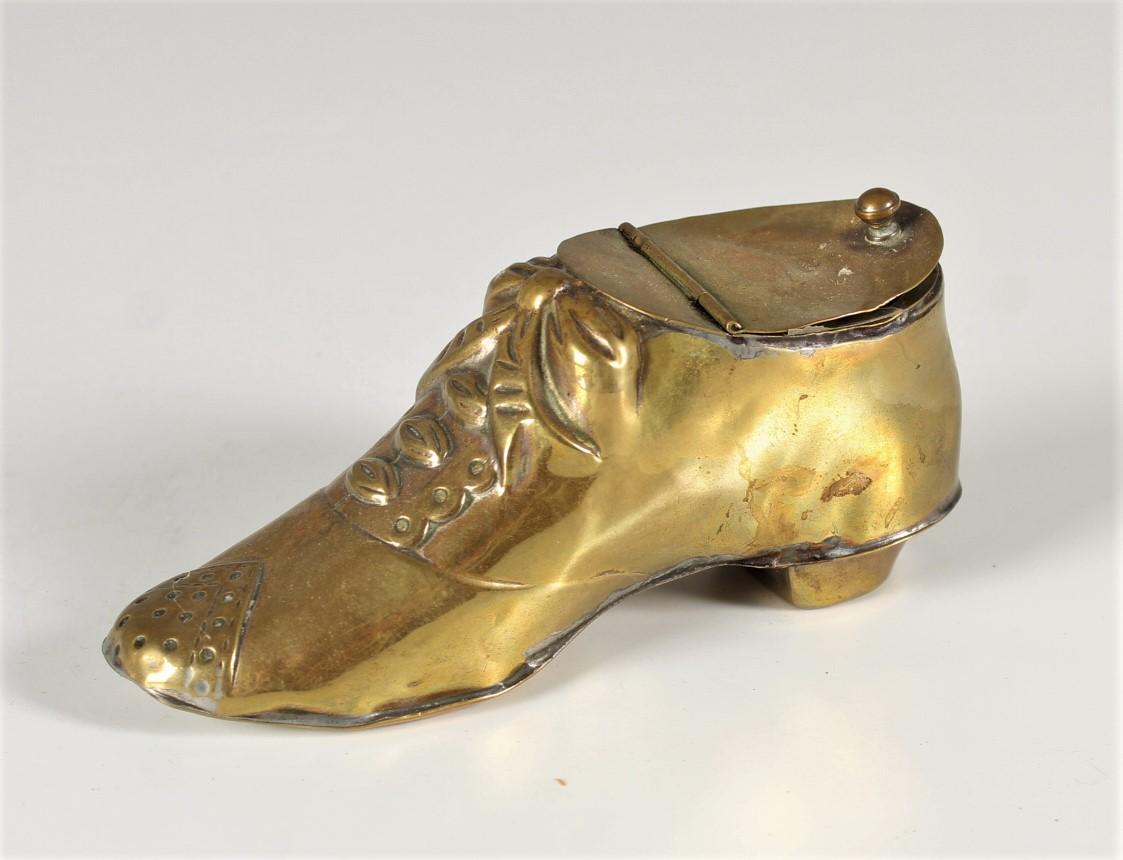 Bel encrier en laiton, qui présente une chaussure ancienne.
France, vers 1910.