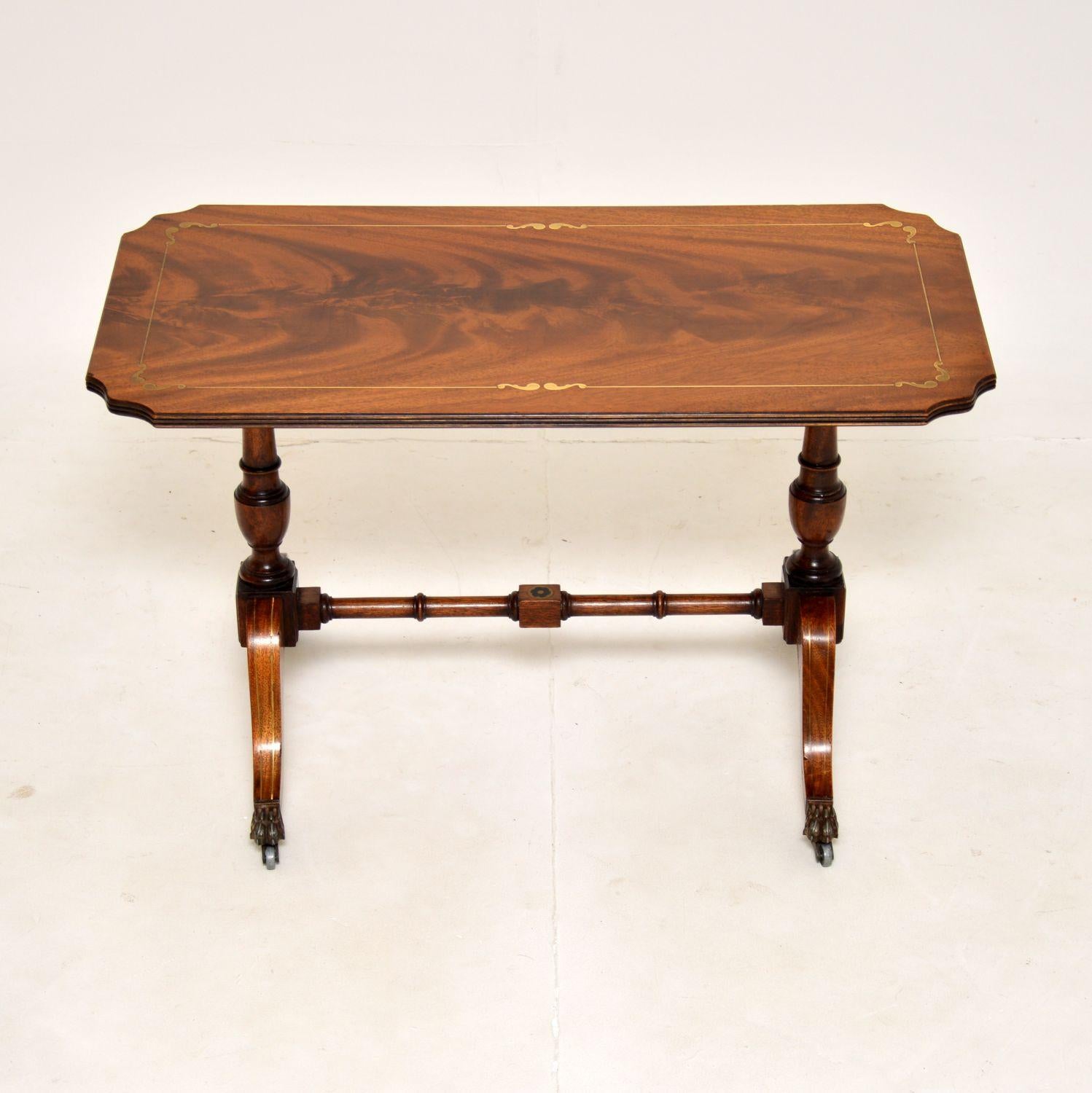 A beautiful little antique coffee table in the Regency style. This was made in England, it dates from around the 1930’s

It is of lovely quality and has a gorgeous design. The flame wood top has amazing grain patterns and has fine inlaid brass
