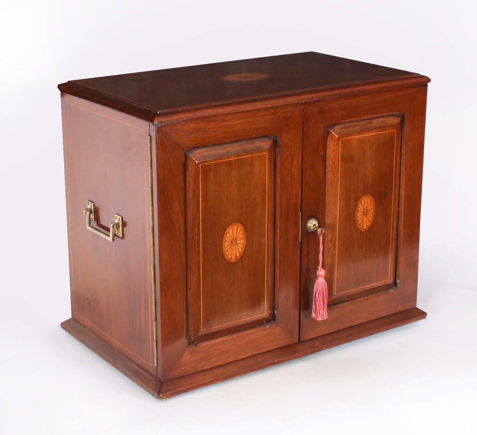 Si tratta di un superbo e raro esemplare di cassa vittoriana in mogano a fiamma, con tre decanter Gentlemans tantalus / Library / communication station di Maple & Co.

Il mobile presenta una decorazione intarsiata in linea di bosso con motivi di