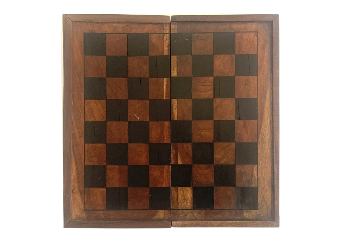 An antique inlaid folding wooden game board with backgammon and checkerboard/chess board on the reverse side. The chess board with individual inlaid boxes and a string inlay border. The backgammon side with inlay ebony and bone decorations, diamond