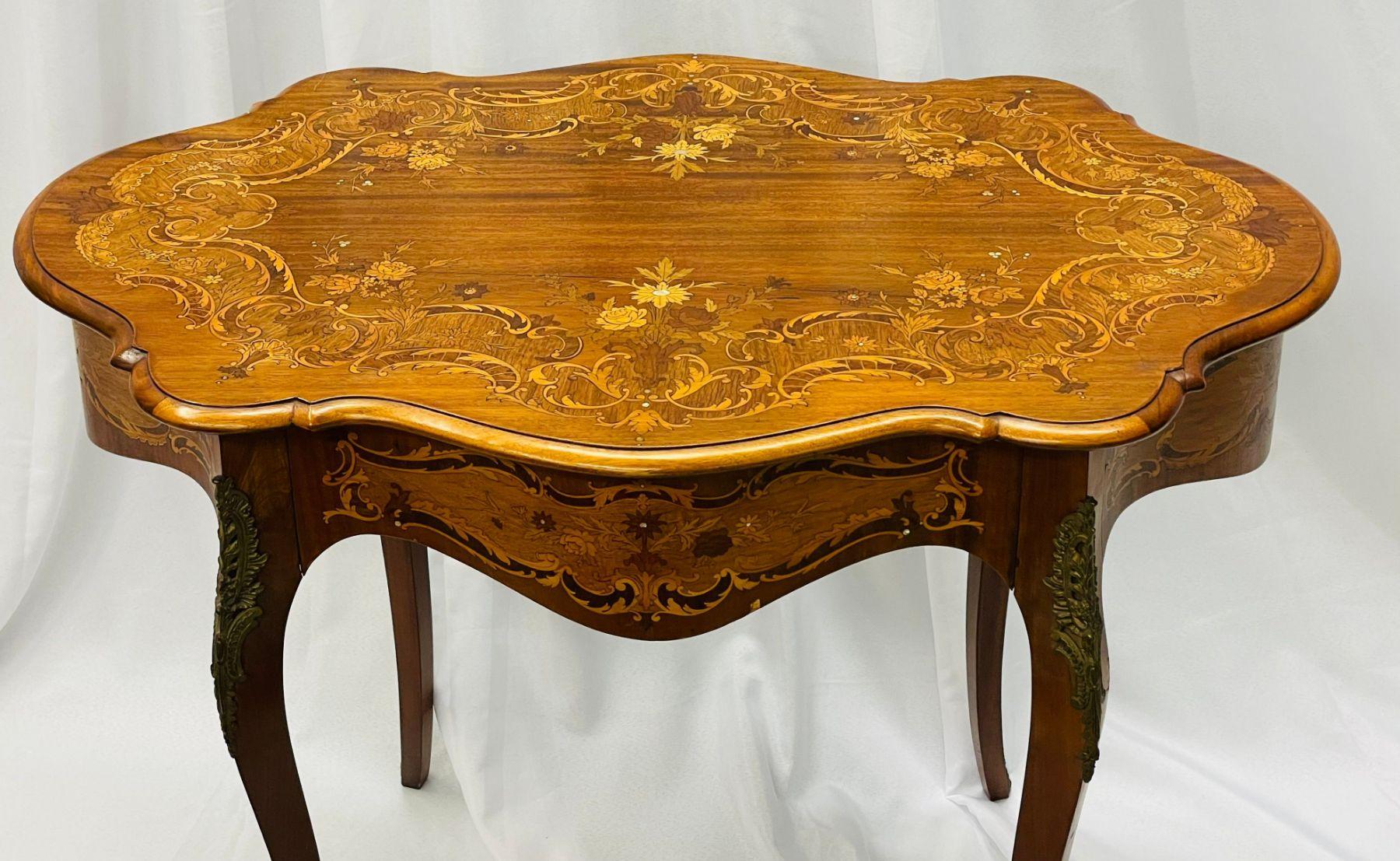 A French satinwood and walnut inlaid accent or center table. This Louis XV Style table having satinwood inlays with mother of pearl details over a large floral design depicting roses and tulips.

Satinwood, Walnut
France, 1930s.