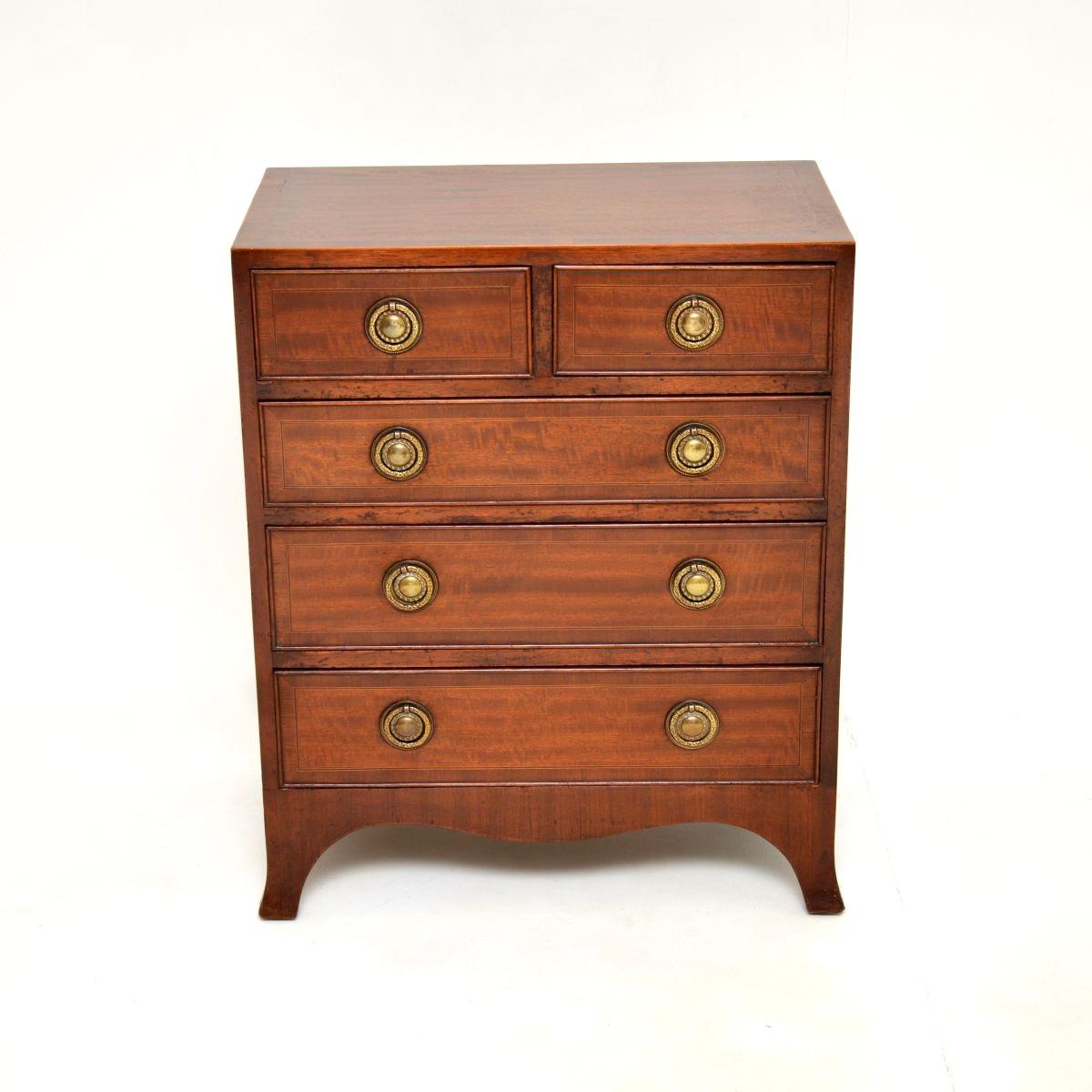 Una meravigliosa cassettiera antica in stile georgiano. Questo modello è stato realizzato in Inghilterra e risale all'incirca agli anni Trenta.

Questo è uno dei due esemplari che abbiamo, identici per forma e dimensioni, con intarsi e manici
