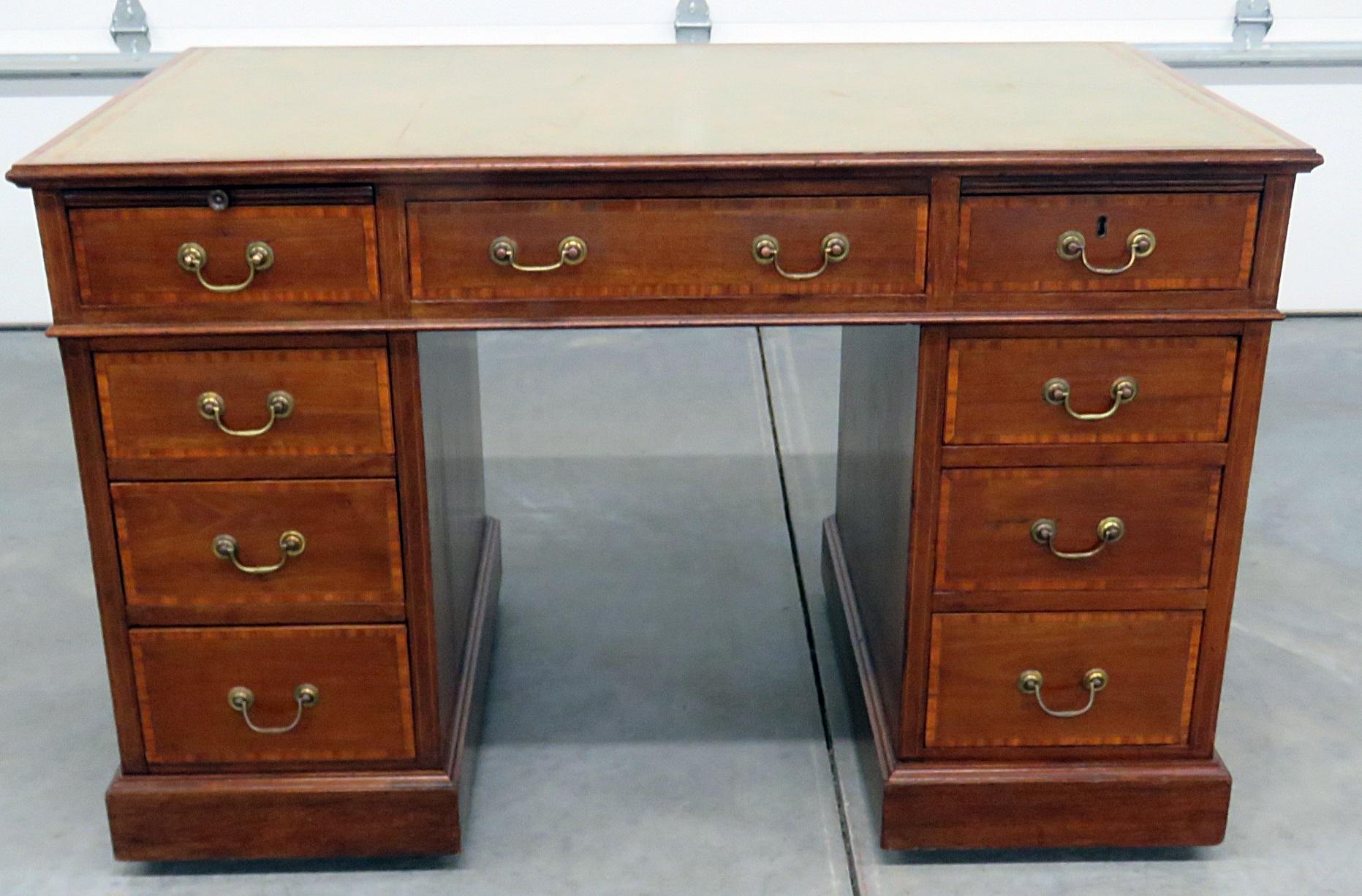 Antique inlaid leather top writing desk with 9 drawers and a pull out writing surface.