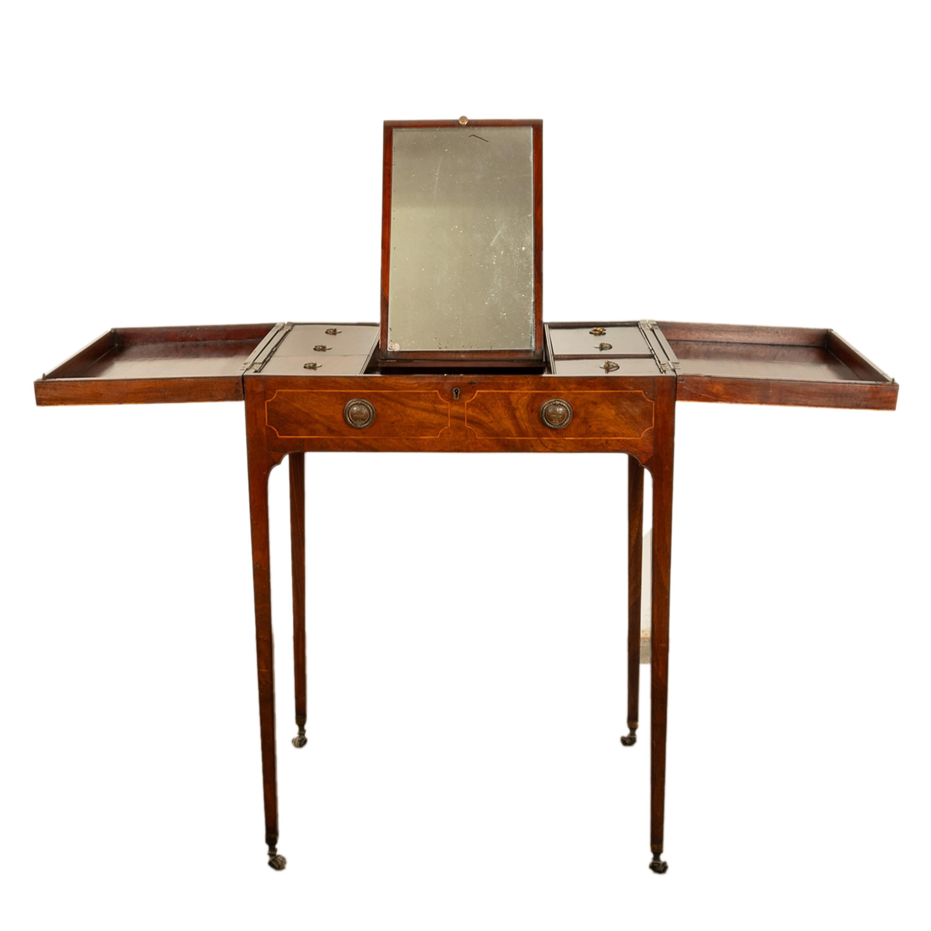 A fine quality antique Georgian inlaid mahogany Sheraton folding vanity dressing table, circa 1780.
The dressing table folds out with a pair of hinged 'wings', when closed it makes a very useful side table, enclosed is a fitted interior with a