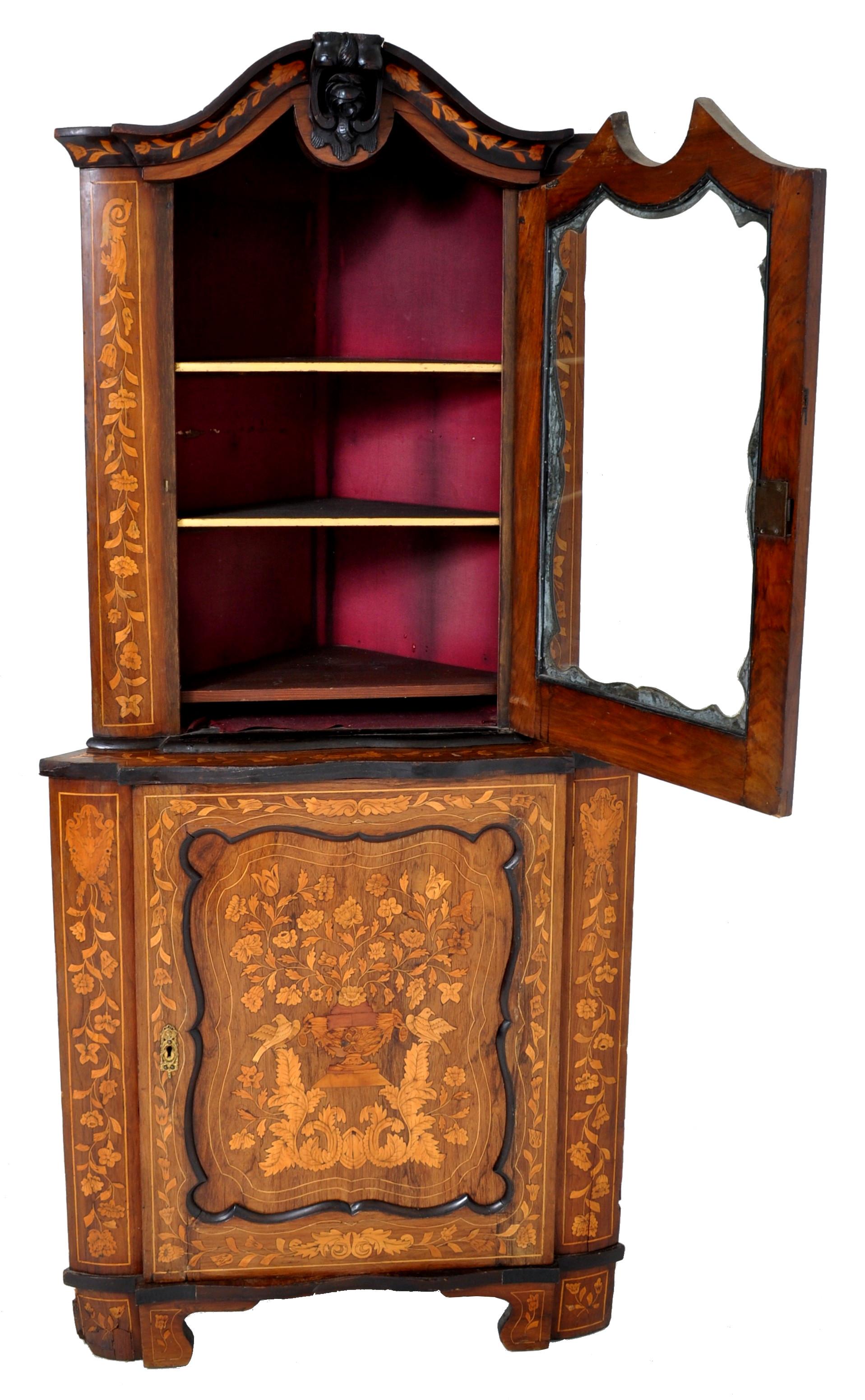 Antique inlaid marquetry Dutch two-piece corner cabinet, circa 1830. The cabinet with an arched top with a carved floral finial to the center, the top section having a single door enclosing two shelves, the base also having a single door enclosing
