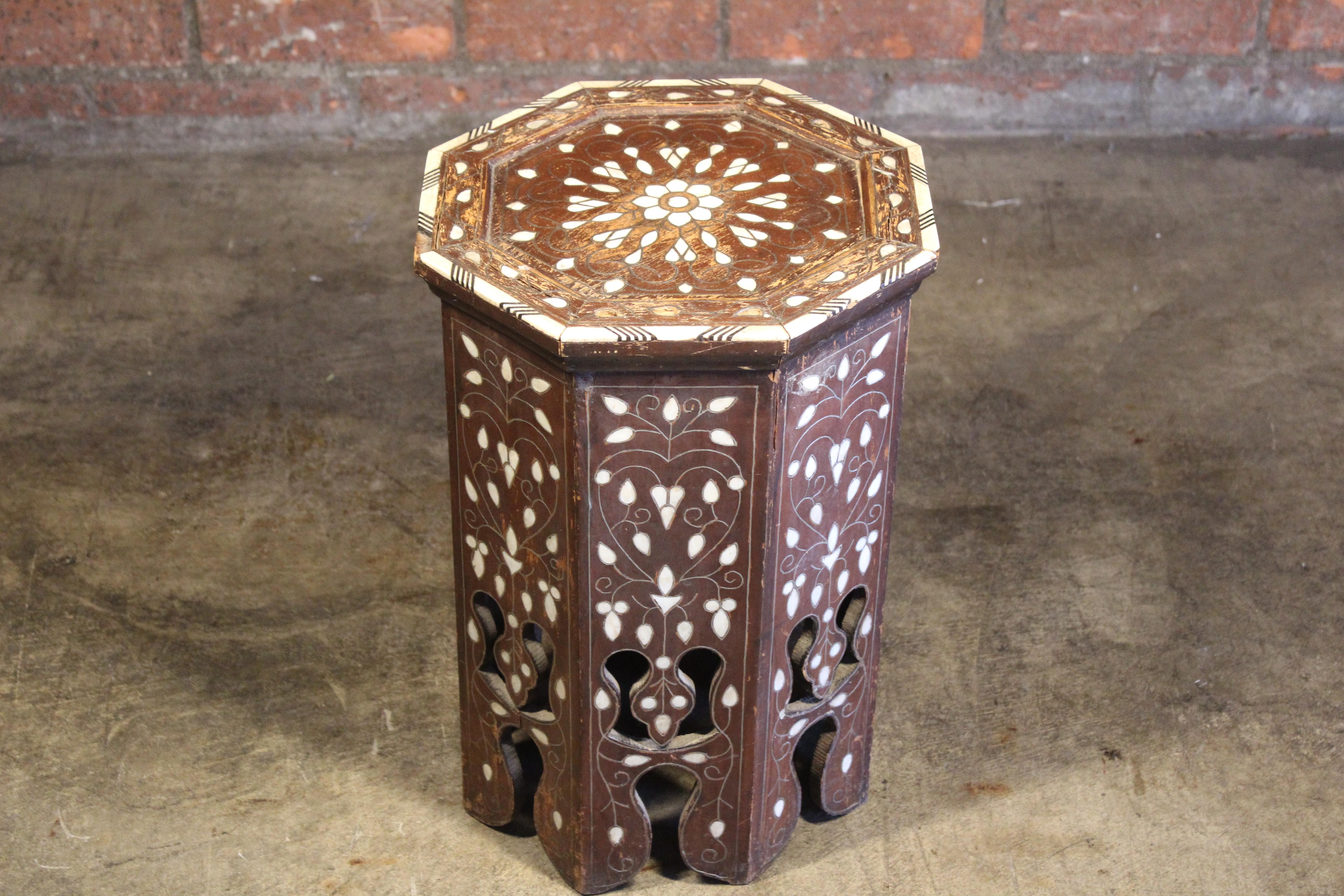 A vintage Moroccan or Islamic style side table with bone inlay. In original condition with signs of wear and minor losses.