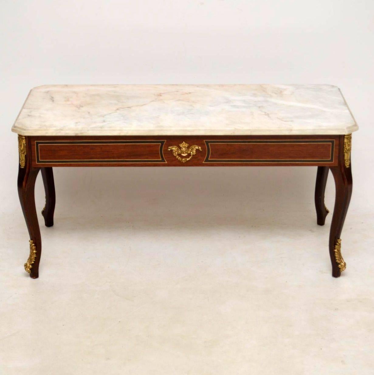 Antique French style marble-top coffee table in excellent condition and dating from around the 1950-1960s period. It’s rosewood with ebony and satinwood inlays. It also has gilt bronze mounts and feet.

Measures: Width 39.5 inches, 100 cm
Depth