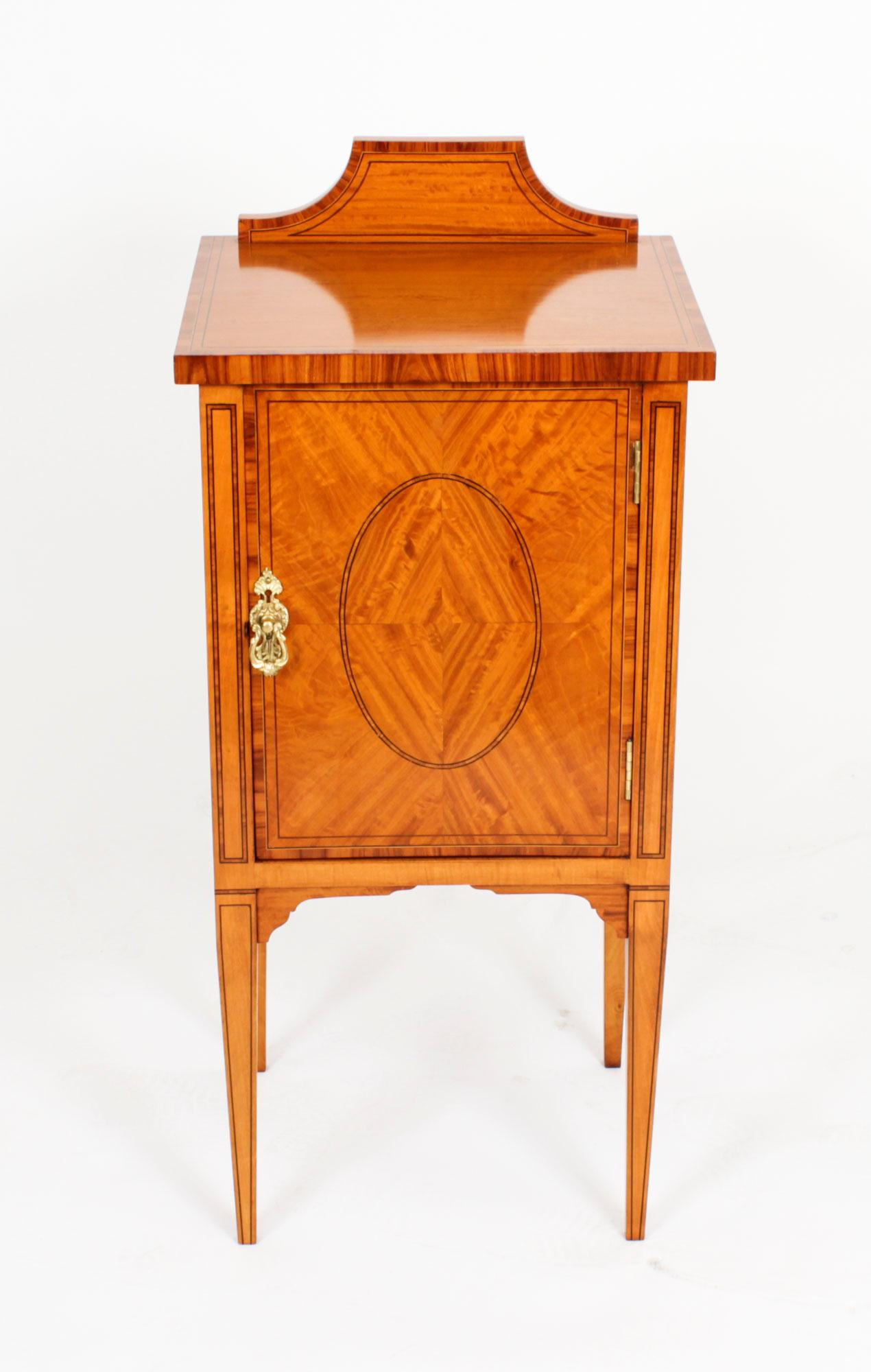 This is a splendid antique Victorian satinwood bedside cabinet, circa 1880 in date.

The cabinet features beautiful satinwood with decorative ebonised line inlay.  It has a frieze drawer above a cupboard with a central shelf and is raised on elegant