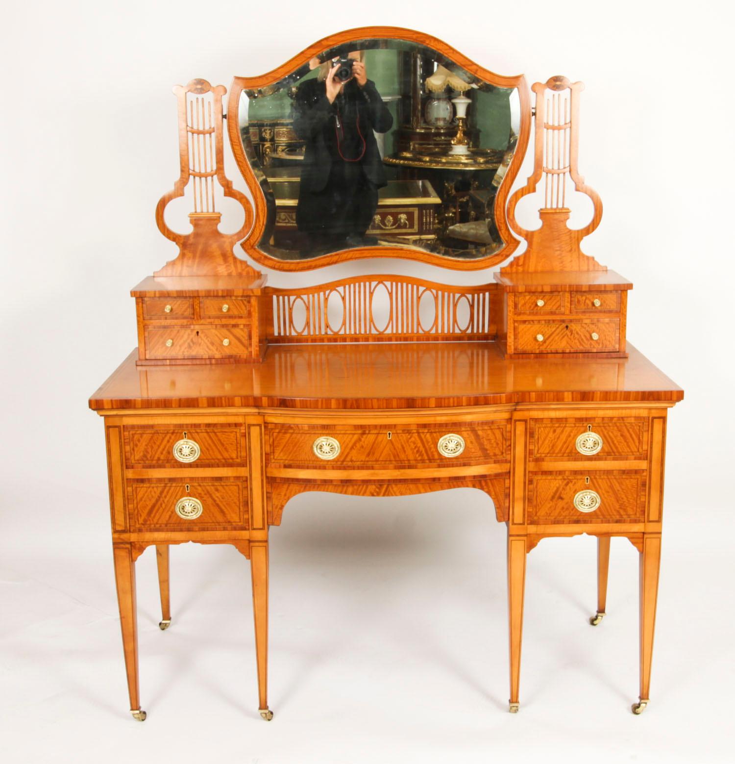 This is a fine antique satinwood serpentine fronted dressing table by the world renowned cabinet maker an retailer Maple & Co, Circa 1880 in date.
 
The stunning satinwood dressing table has boxwood and ebonised stringing inlay and crossbanding