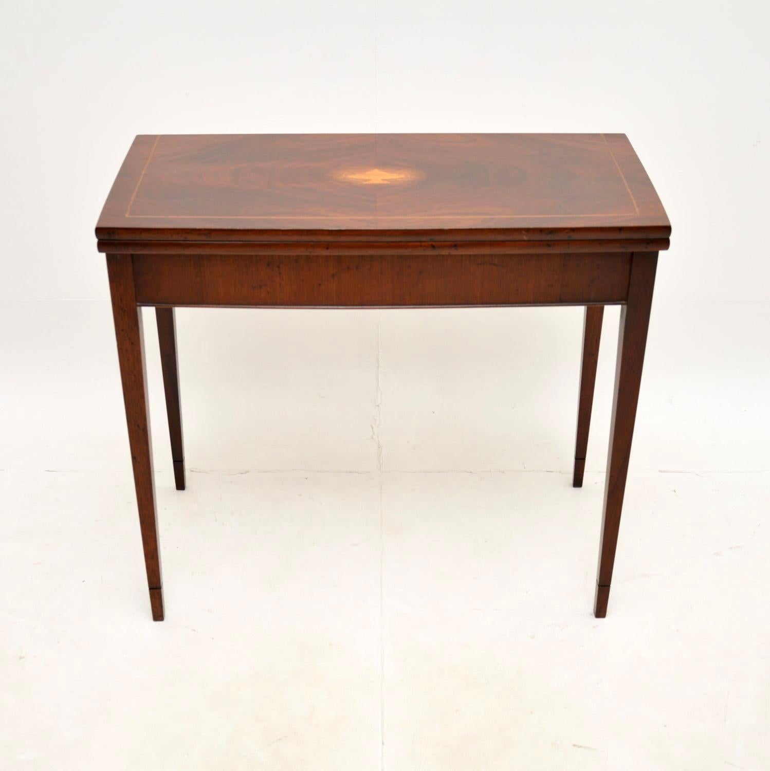 A lovely antique inlaid card / console table in the Georgian style. This was made in England, it dates from around the 1950’s.

It is of superb quality and is a very useful size to be used as a console table. The top swivels round and flips open to