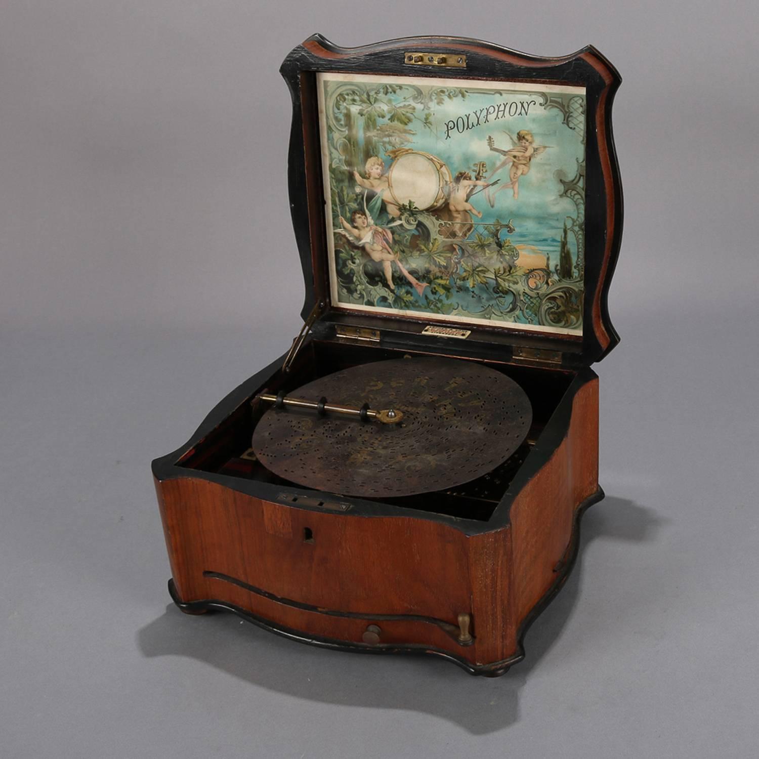 Antique Polyphon music box by Schutz & Marke features inlaid and banded walnut case with interior Classical cherub scene and comes with thirteen working 8