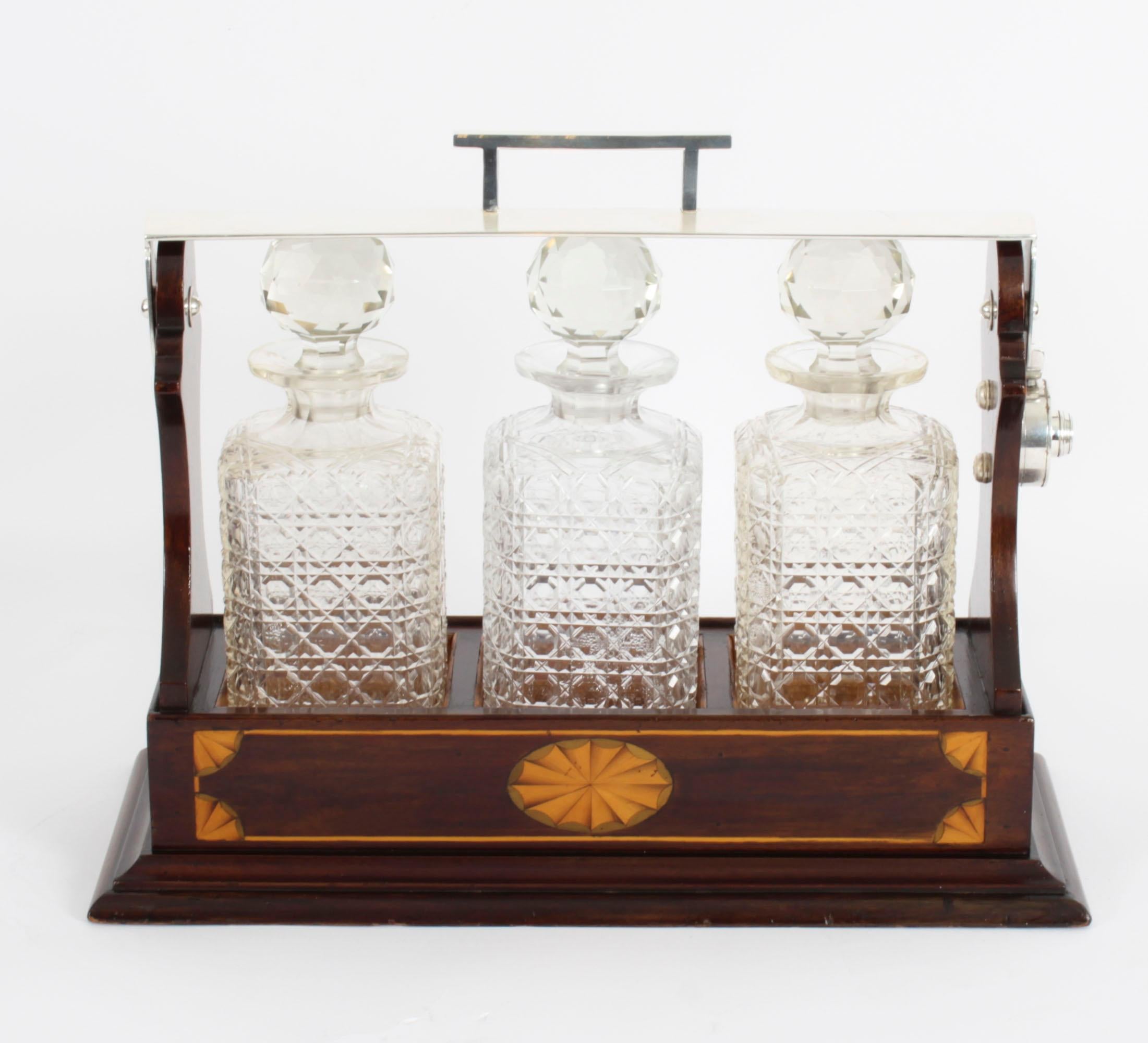 This is a superb antique Victorian walnut cased three decanter tantalus with decorative inlaid satinwood decoration, c1870 in date.
 
It was skillfully crafted in walnut with beautiful fan and line inlaid decoration and a stylish silver plated