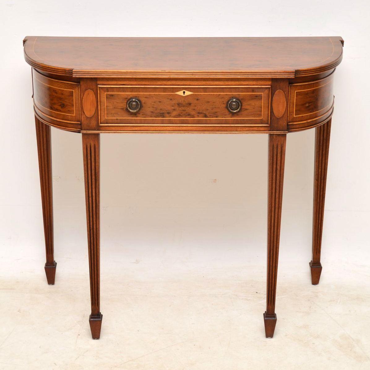 This antique Georgian style yew wood console table is fine quality and has many intricate features. The top, the drawer and the curved sides are all yew wood, with satinwood inlays and cross banding. The top front edge is reeded and the tapered