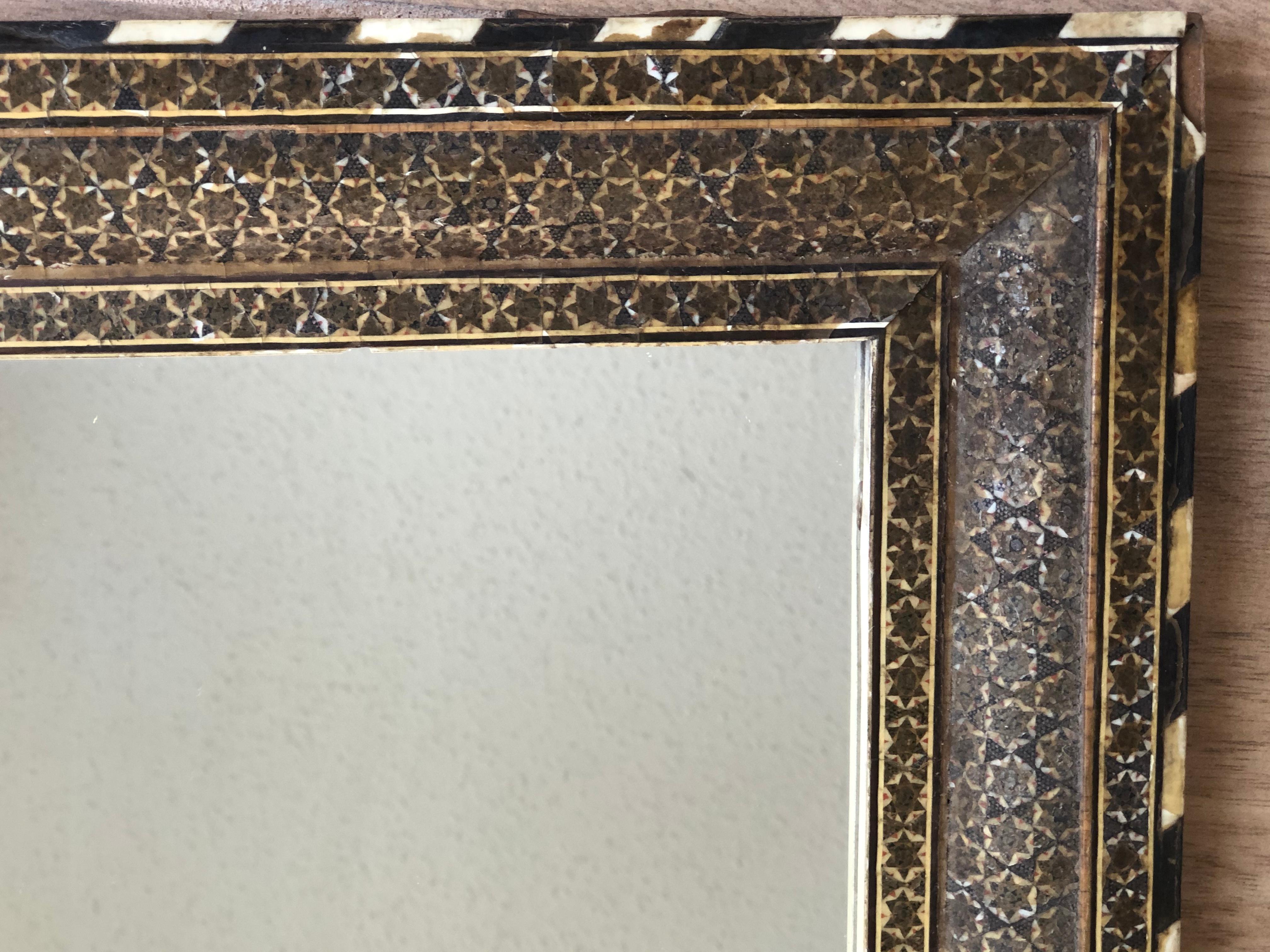 This beautiful one of a kind Rustin middle eastern mirror is inlaid with mother of pearl and bone inlay on a rectangular shaped wooden frame. Colors of dark browns to light. 

Mirror is as is and has a few chips from natural wear and tear pictured