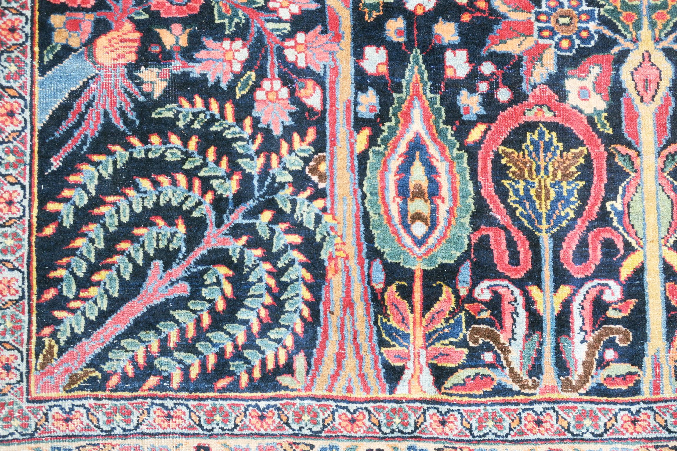 This is a very special rug with a tree of life design, dating from circa 1910, inscribed at one end and clearly commissioned for a special event. The tree is in full bloom and the design contains a forest of smaller trees and shrubs bursting with