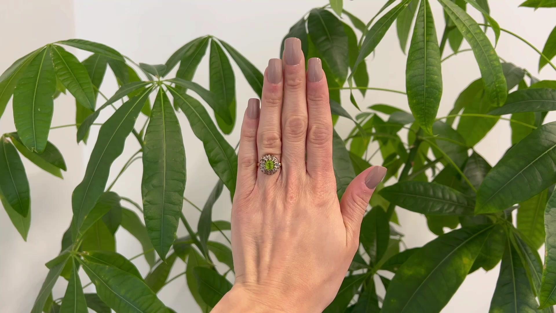 One Antique Inspired 1.73 Carats Peridot Diamond 14 Karat Gold Cluster Ring. Featuring one oval mixed cut peridot weighing 1.73 carats. Accented by 10 senaille cut diamonds with a total weight of approximately 0.20 carat, graded I color, I1 clarity.