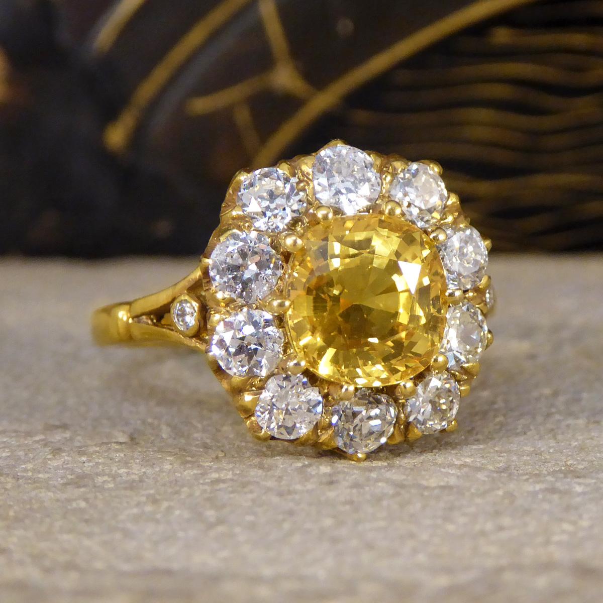 Dieser wunderschöne Ring enthält einen gelben Saphir mit einem Gewicht von 2.60 ct, der in einer Goldfassung mit zehn Krallen sicher befestigt ist. Der gelbe Saphir ist von 10 Diamanten im alten europäischen Schliff mit einem Gesamtgewicht von 1,30
