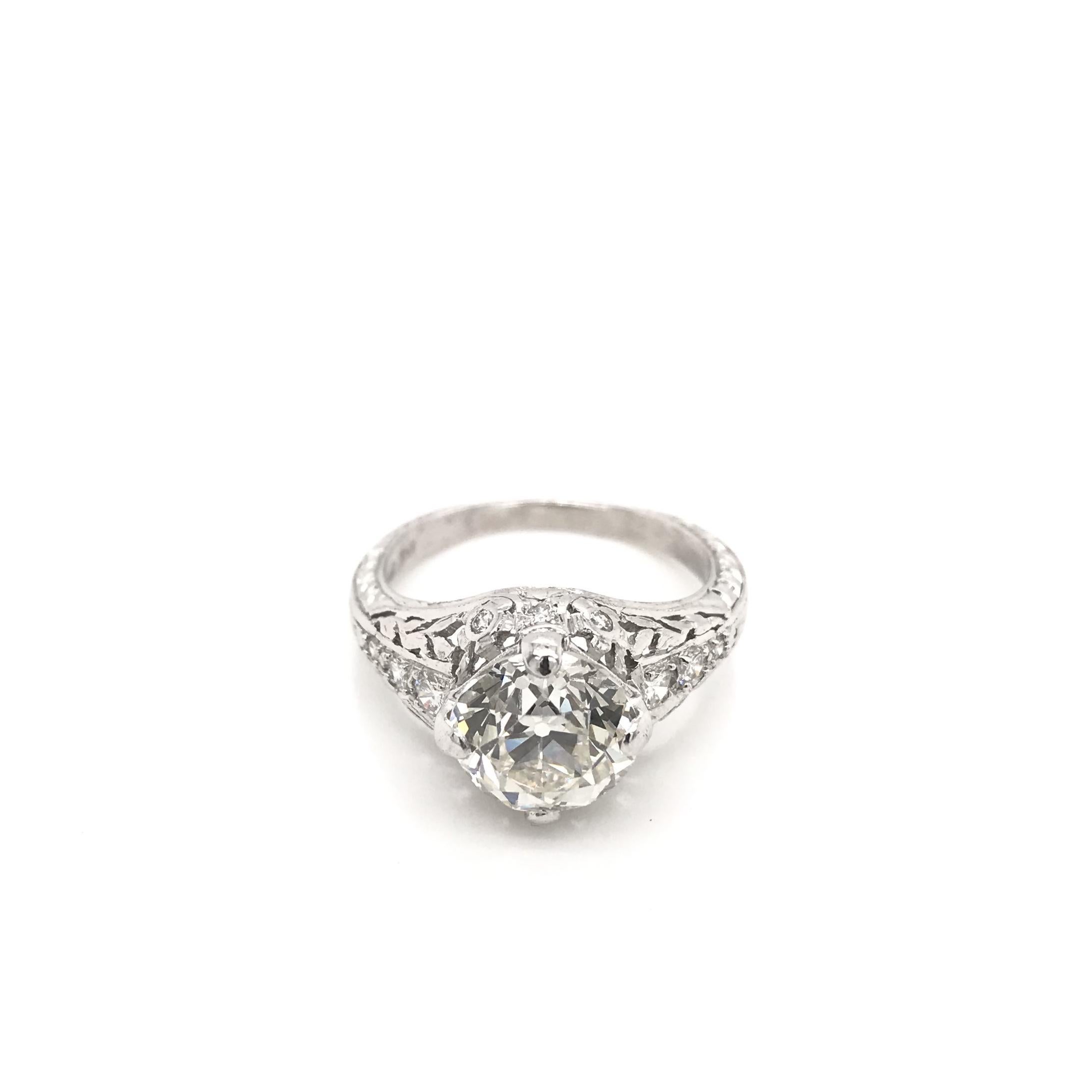 This contemporary estate filigree ring features a center diamond measuring approximately 2.75 carats. The center diamond is an antique Old European cut that has been certified by the Gemological Institute of America. The diamond grades approximately