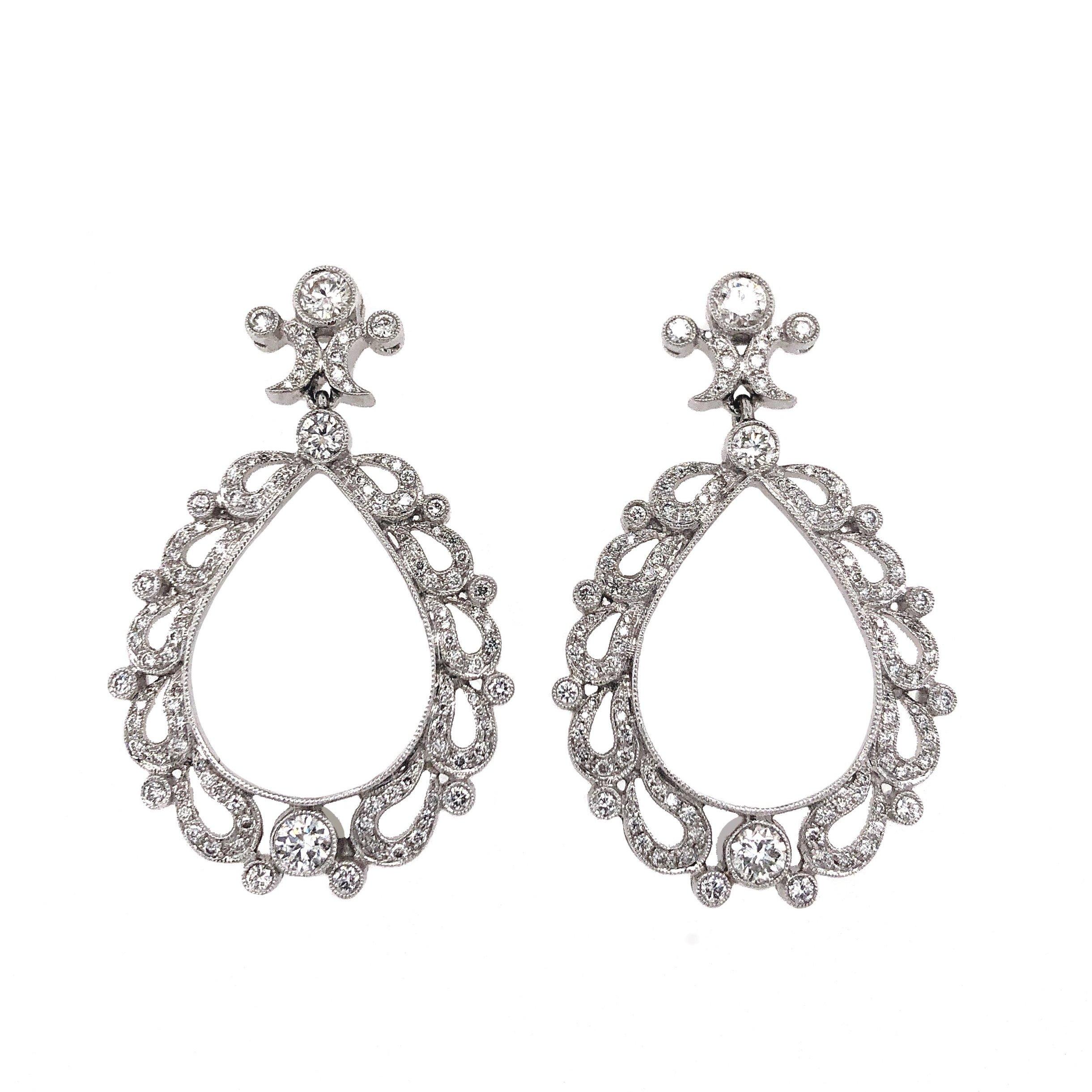 Crafted from 18K White Gold, these Pear Shaped Chandelier Drop Earrings flaunt Pavé Diamonds and Round Brilliant Diamonds totaling 1.99 carats. The diamonds are deemed F in Color and VS in Clarity with excellent make and polish. The ornate design