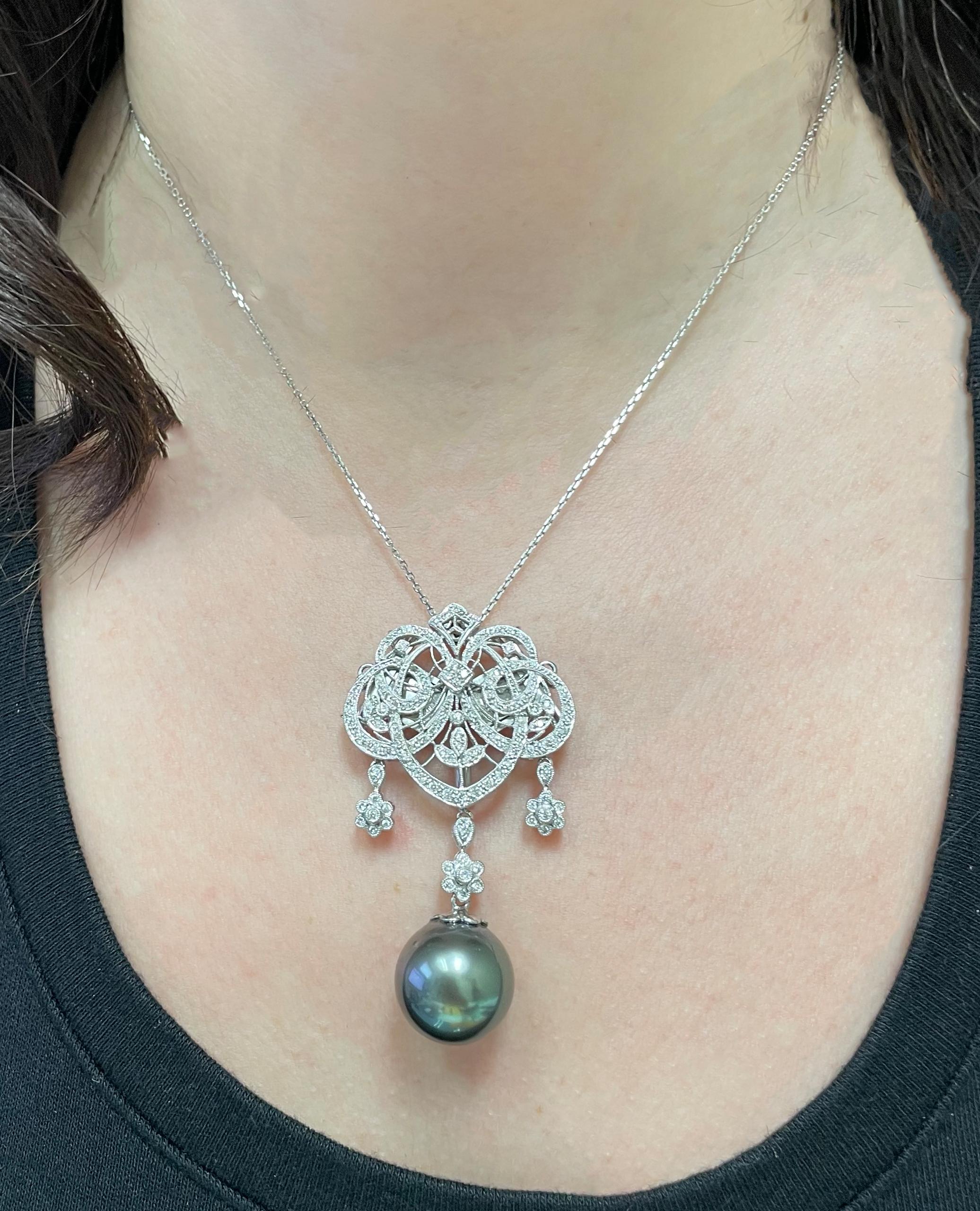 Antik inspirierter Anhänger aus 18 Karat Weißgold mit runden Diamanten und einer grün-schwarzen Tahiti-Südseeperle von 15,75 mm.  Der Anhänger kann auch als Brosche getragen werden.  Der Anhänger hängt an einer Kabelkette aus 14 Karat Weißgold. 

-