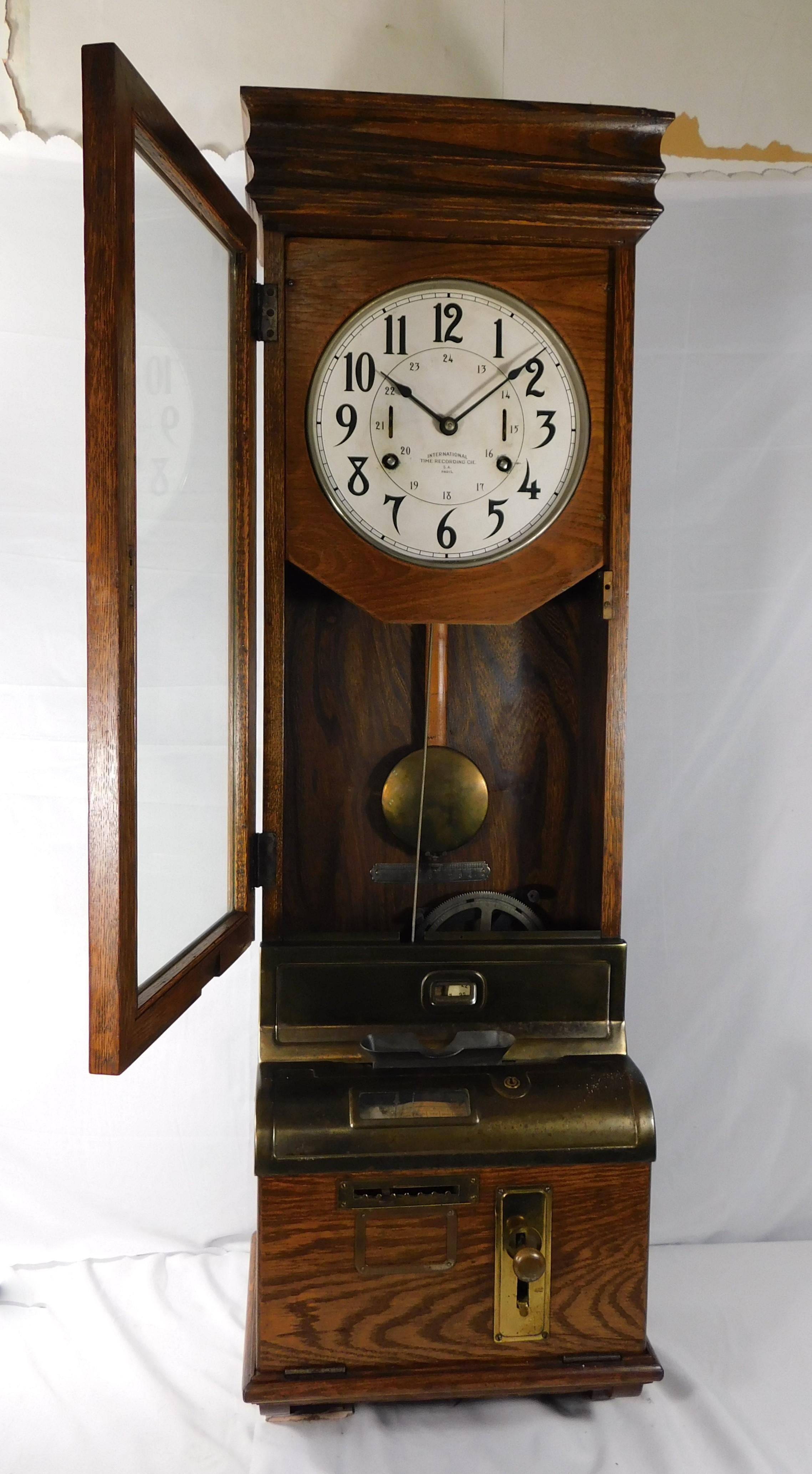Clock face says International Time Recording CIE. S.A. Paris, industrial mechanical time card punch clock machine age Circa 1900 made in New York U.S.A. and exported to France. The oak case houses a rounded face with numerals in black. with brass