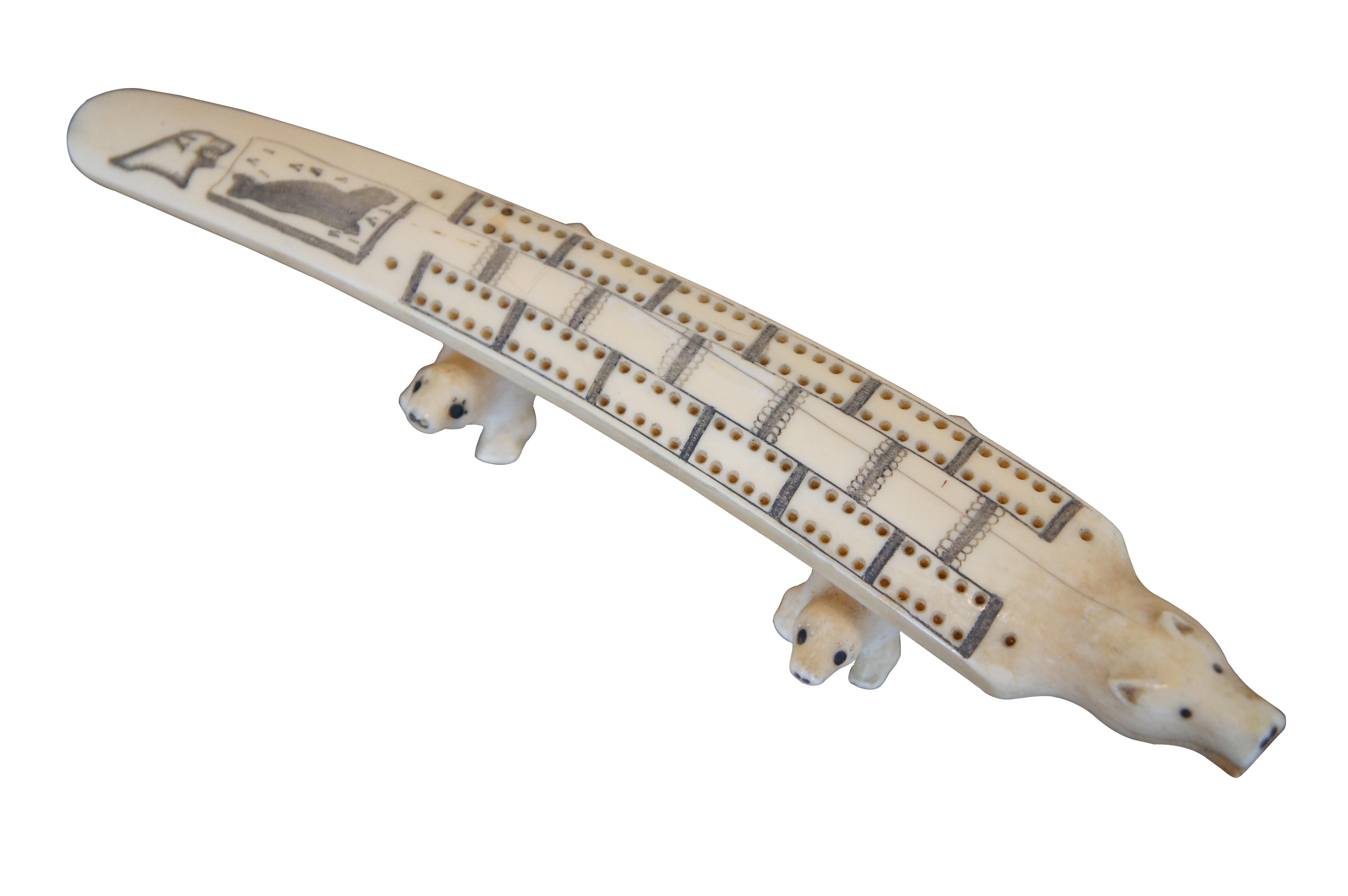 Antique Inuit folk art carved bone cribbage board featuring a Polar Bear propped up by Seals. Measure: 10